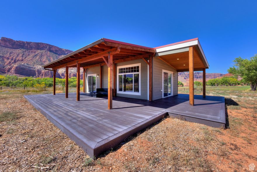 This 6.3-acre property is larger than most in the valley and comes with six valuable water shares and solar power for sustainable living. 5.3 acres are taxed as greenbelt, and 1 acre is taxed residential. At the entrance, you'll find a versatile building perfect as an artist's retreat, remote work haven, or guest quarters, featuring bamboo flooring, mini-split heating/cooling, hot water heater, sink, a basement with egress and a spacious deck with stunning views. RV hookups are adjacent to the studio. Adjacent to this retreat space is a 40 ft x 10 ft x 4 ft irrigation pond with its own deck. This unique feature can double as a place to cool down or as an irrigation source for the property. An 8-foot deer fence surrounds the area, creating the perfect protected spot for your dream garden. The Clayton Homes manufactured residence is efficient and comfortable, offering one bedroom, one bathroom, and its own mini-split system and its own hot water heater. Live here while building your dream home or simply enjoy the charm and simplicity it provides. This space has also served as a successful long-term Airbnb rental, generating $1,300$1,800 per month. For equestrian and homesteading enthusiasts, there's a large horse pasture, a shade structure for horses, a shipping container on a foundation for hay storage, and a secure space for smaller animals such as goats or chickens. With its ample water, solar power, unique structures, and breathtaking views, this Castle Valley property offers endless potential-whether you envision an escape, a creative retreat, or a small farmstead.