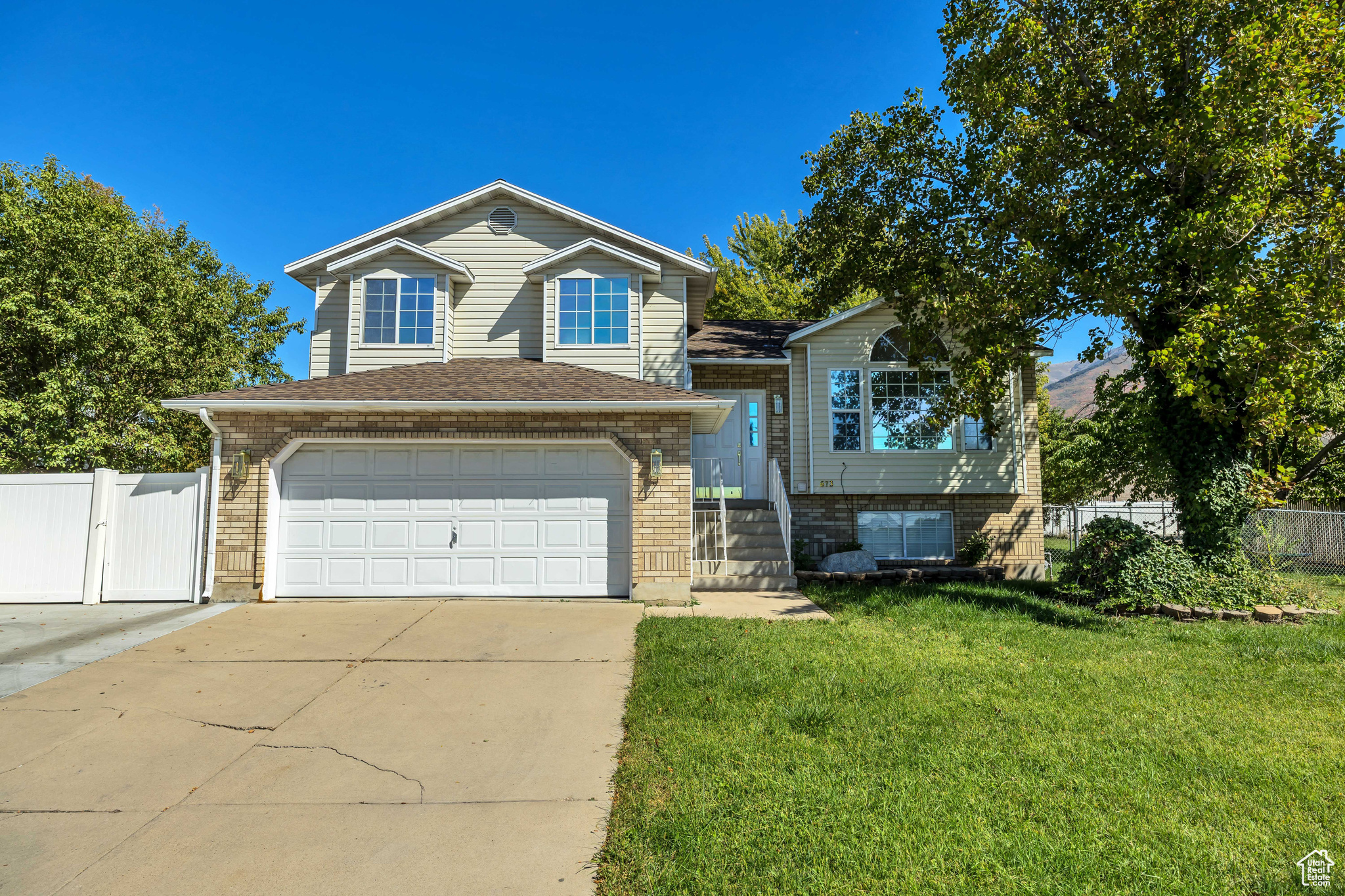 Must See! This beautiful tri-level home in desirable East Kaysville has everything you need to make it your next home. Featuring newer paint and 100% wood flooring on the main levels, this well-cared-for property offers comfort, flexibility, and charm. A unique highlight is the second kitchen and laundry area, ideal for a mother-in-law suite, future ADU or optional rental income with an independent entrance into a spacious family room. The large lot is a true retreat with mature apple and cherry trees, a fully fenced backyard, garden space, fire pit, and plenty of room for gatherings. Practical features include RV parking, ample driveway space, a full sprinkler system, and secondary irrigation water ($180/year, March through October). Conveniently located within walking distance to schools, parks, ponds, and trails. Easy access to HWY 89 and I-15, and just minutes from Lagoon, Cherry Hill, Station Park, and the Frontrunner. Square footage figures are provided as a courtesy estimate only. Buyer is advised to obtain an independent measurement.
