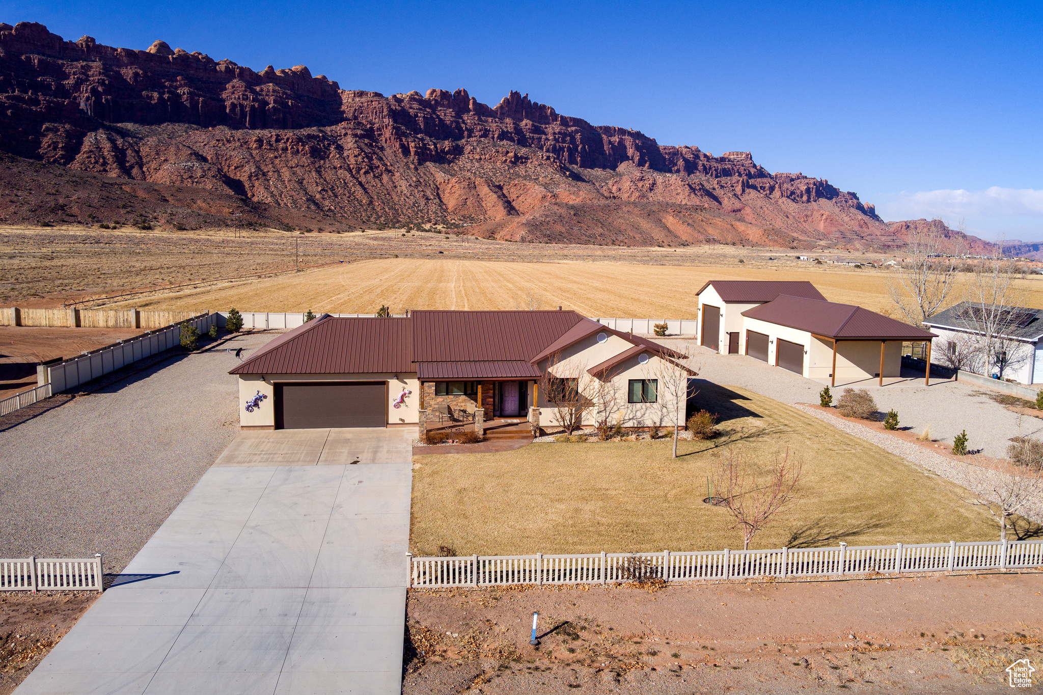 AMAZING RENOVATED and furnished HOME with 6 CAR GARAGE AND RV BAY, ideal for storing your 4X4's, boats, RVs and recreational vehicles. This beautiful stone and stucco ranch features a welcoming covered front porch with breathtaking views of the snow capped La Sal Mountains and surrounding red rock. Inside, the entry leads directly into the great room featuring soaring vaulted ceilings, transom windows, Hickory wood floors, floor to ceiling stone fireplace and a wall of glass doors and windows leading out to a stylish covered deck that overlooks the Moab Rim. From here step down onto a stained stamped concrete patio complete with benches and firepit. This is the perfect gathering place. The light filled kitchen includes double ovens, glass cooktop, stainless steel appliances and ample counterspace. Conveniently located off the kitchen is the laundry room, 2-car garage, 1 full bath, and a spacious private office that could also be used as a bedroom. On the opposite side you will find the beautiful Primary bedroom with ensuite bath, that includes walk-in shower, soaking tub, dual sinks and huge walk-in closet. There are two more bedrooms and 1 bath on the main level. The lower level has a large gathering room, 1 full bath, 1 bedroom, 1 den, and 2 spacious storage rooms. Outside, enjoy a fully landscaped yard with multiple pine and shade trees, flower beds, and a gravel pull-through driveway for your larger rigs. The amazing GARAGE/SHOP features RV parking, water/sewer hookups, and space for 4 more vehicles. This is a must see property in Moab. The property tax amount is for a secondary residence. If this is to be a primary residence, the tax will be much lower.  All info deemed to be reliable, but buyer to verify all.