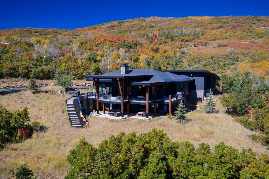 Top of the World Views! in this Stunning Mountain Modern Retreat in The Preserve.  Welcome to your private oasis in Park City's exclusive gated community, The Preserve. This 5,000 sq. ft. home completed in 2019, is set on over 14 acres with breathtaking views of the mountains, ski resorts, and the entire valley. Upon entering, you're greeted by a light filled spacious living and dining area that seamlessly blends elegance and comfort, featuring radiant heated European white oak flooring, a custom gas fireplace, and exquisite lighting. Expansive LaCantina bifold doors open to a large covered outdoor deck, ideal for entertaining, al fresco dining, or soaking in the hot tub while watching the spectacular sunrises and sunsets. The generous chef's kitchen is equipped with Wolf and Asko appliances, an impressive custom wine cabinet and butlers pantry for added convenience. The main level master offers a spa like bathroom complete with soaking tub, steam shower and spacious closet with laundry. A main floor office adds to the functionality of this home. On the lower level discover a large living room with wet bar, 3 additional bedrooms, 2 bathrooms, a home theatre/gym and ample storage. The property includes a heated 3 car oversized garage with work bench, hose bibs and storage and the ability to add a 2500 sq. ft. guest home if desired. This beautiful home is ultra private yet remarkably accessible, just 10 min. from shopping and dining and 35 min from SLC International airport. Experience the perfect blend of luxury and nature in this exquisite Park City residence-your mountain modern retreat awaits!