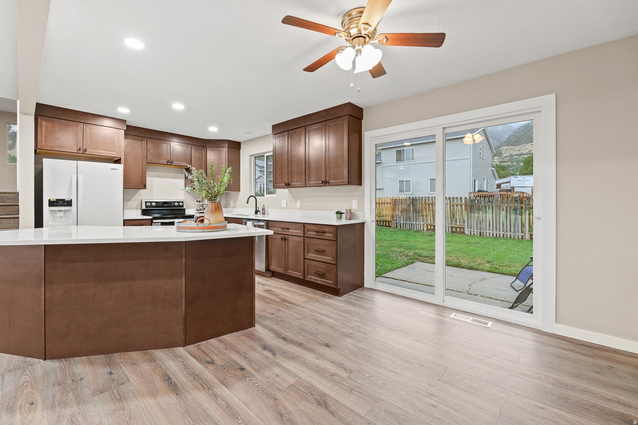 Wood-like flooring, recessed lighting, and a ceiling fan