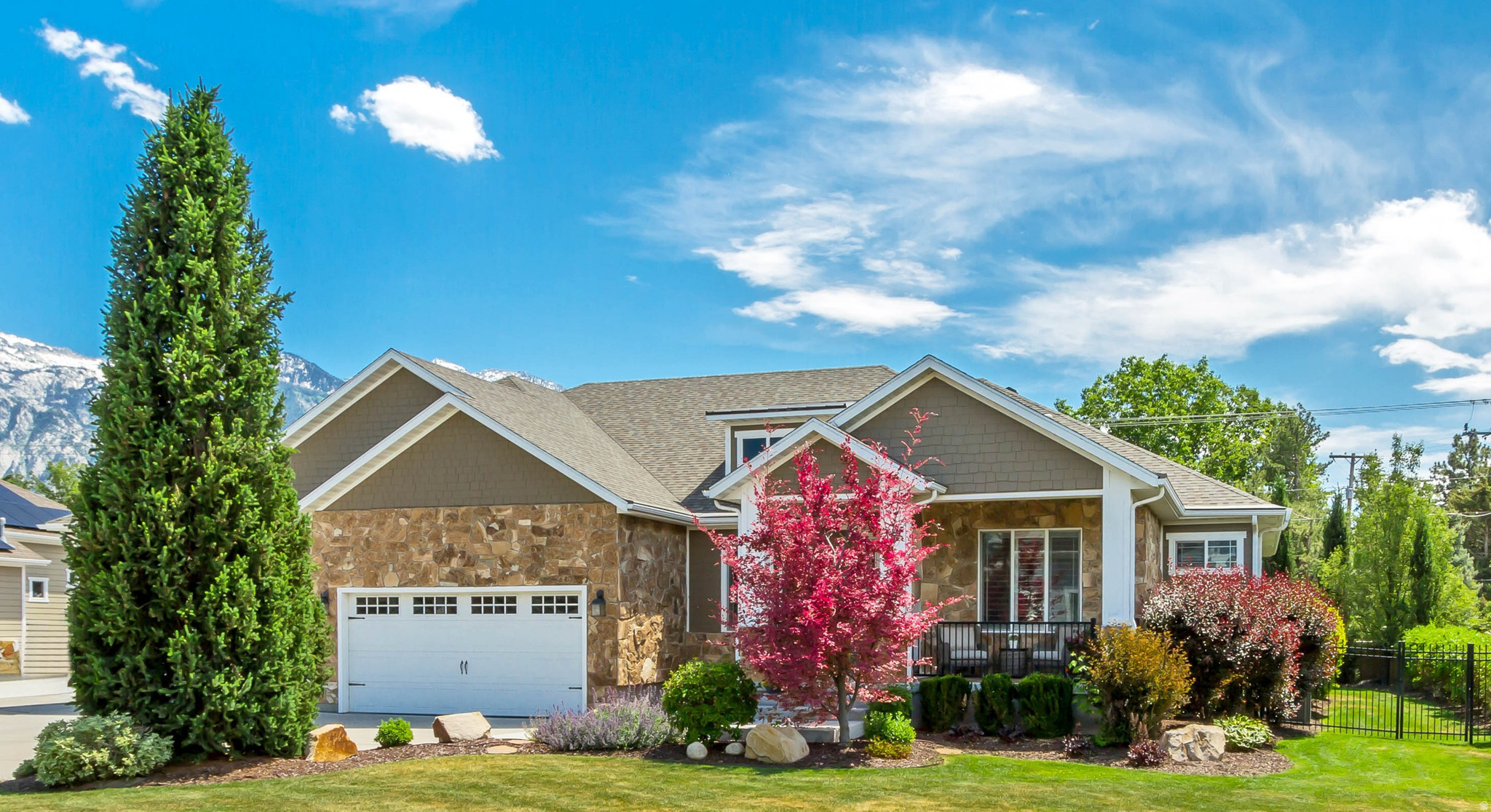 Craftsman inspired home with stone siding, driveway, a garage, a mountain view, and a porch
