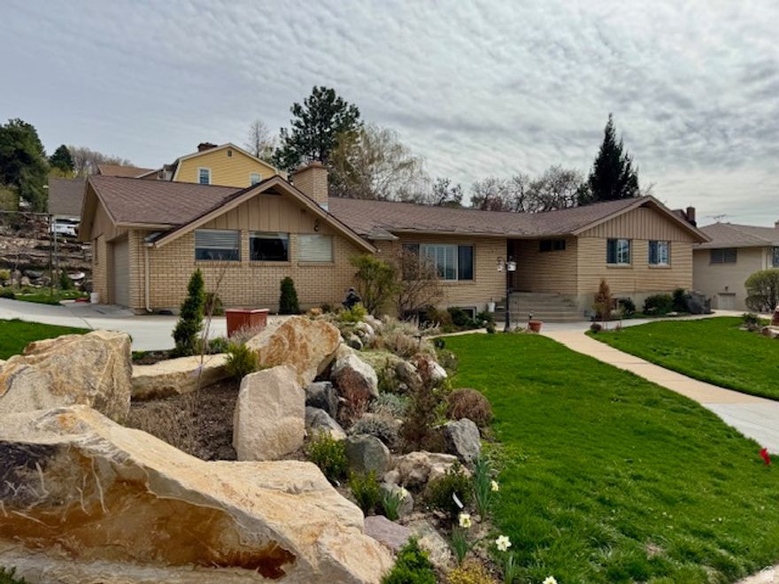 Offering spacious, open living on the bench above Weber State University, this well-built brick rambler showcases quality construction and timeless features throughout. Highlights include rich cherry kitchen cabinetry, grand fireplace, a formal dining room, and an inviting layout designed for both comfort and entertaining. The owner's suite provides a peaceful retreat with two closets and plenty of room to relax. The main level features a large living room ideal for gatherings, along with a dedicated den-perfect for working from home or quiet reading time. The basement includes a separate entrance, two additional bedrooms, a game room, and two expansive family rooms, including a fireplace, offering exceptional flexibility and space for everyone. Warm, welcoming, and thoughtfully designed, this home is the perfect place to create lasting memories.