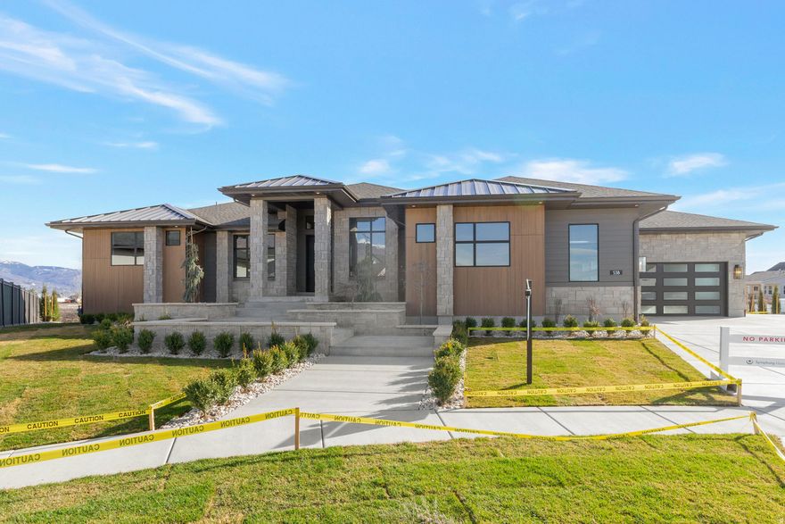 LOT#513. This thoughtfully designed "Adagio" plan home features a luxurious main-floor primary suite with decorative tray ceiling, custom millwork and cabinetry, a cozy sitting area with fireplace, an impressive spa-style bathroom with a huge walk-in shower, and a spacious custom wardrobe room complete with a stackable laundry hookup for convenience. Both a flex room and an office greet you at the entry before opening into the impressive great room. The kitchen is beautifully appointed with high-end appliances, built-in column fridge and freezer, a large butler's pantry, and a convenient pocket office (or craft room). The dining nook flows seamlessly to the covered deck, creating an ideal indoor/outdoor living space. The fully finished basement offers three additional bedrooms, two bathrooms, a huge laundry room, an open game room, a stylish wet bar, and walk-out access to a covered patio. Additional features include a cold cellar, active radon mitigation system, and a 4-car finished garage. A stunning blend of craftsmanship and comfort-don't miss this one.