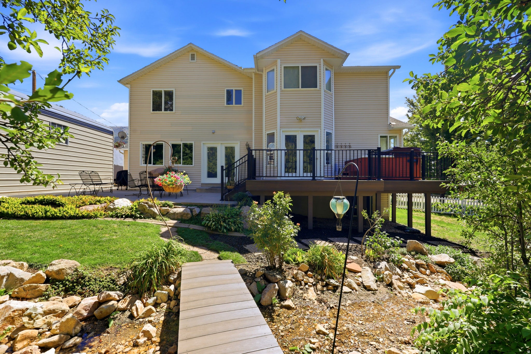 Expansive elevated deck with black railing and built-in hot tub