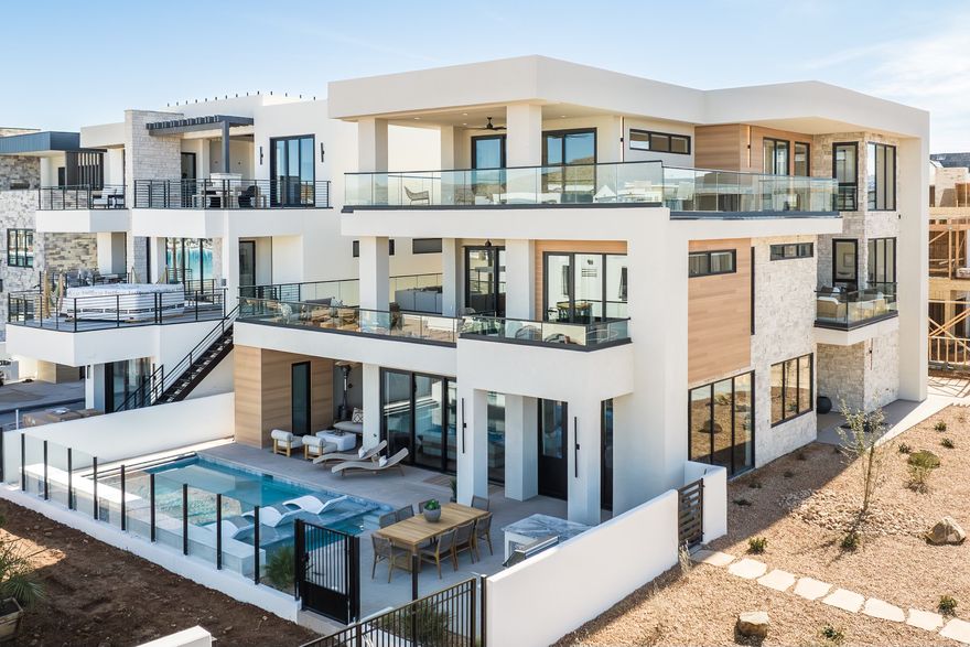 When you live in the desert, but you love the beach, you go to Desert Color as often as possible. Now is your chance to become an owner in this St George resort style community for 1/8th of the cost. The home is being sold in 1/8th ownership shares (Price reflected in listing per 1/8th). This Co-Ownership home features a stunning three level custom design, and is located on the south shore of the 2.5 acre Desert Color lagoon. Billed as the "The Deseret Sapphire," the Beach Modern estate features close access to the lagoon and is surrounded by beautiful white sand. The sleeping accommodations suit 24+. There are so many premium features to list throughout this architectural marvel, but I will name a few. The home's open floor plan touts an iconic floating staircase, fold-away exterior doors on every level, and bursts of daylight and fresh air throughout the home. Soak in the views from the private pool/hot tub or any of the 4 separate decks comprising 1500 sq. ft. After a fun-filled day of soaking-up the sun, gather your guests for a movie night in your private theater. Fully furnished and professionally managed, this one of a kind masterpiece was featured in the 2024 St. George Parade of Homes. Only 1 of the ownership shares is available. Square footage figures are provided as a courtesy estimate only and were obtained from the Builder's plans. Buyer is advised to obtain an independent measurement. Call/text or email for additional details on monthly operating costs.