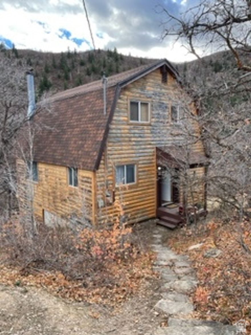 This listing includes Two Parcels: Lot 152, Oak Haven No. 1, Amended according to the official Plat thereof on file in the office of the Wasatch County Recorder (also described as Tax Parcel ID 00-0001-7124) known by the informational address of 1883 W. Sage Cir., Midway, UT 84049 which is approximately 0.71 acres AND adjacent Lot 153, Oak Haven No. 1, Amended according to the official Plat thereof on file in the office of the Wasatch County Recorder (also described as Tax Parcel ID 00-0001-7132) known by the informational address of 1887 W. Sage Cir., Midway, UT 84049 which is approximately 0.72 acres.    Nestled high above the beautiful Heber Valley, tucked away on a quiet, private circle in Oak Haven, this charming Midway cabin offers a rare combination of solitude, stunning canyon views, and year-round accessibility. Built in 1981, the cabin sits on Lot 152 and this sale also includes the adjacent Lot 153, which could possibly be used to build an additional dwelling.  Use both together for a total of 1.43 acres of privacy and open space or hold for the future potential of selling off the additional lot.    The cabin features 1,011 square feet of above-grade living space with three bedrooms and one bathroom, plus an unfinished 588-square-foot basement ready to be built out in an amazing game room or additional sleeping quarters.  A septic system serves the home, and off-street outdoor parking for two vehicles adds convenience.  Designed as a passive solar cabin (no active solar), the home maintains a comfortable temperature most of the year with minimal need for heating or cooling-making it both efficient and inexpensive to maintain. The setting is exceptionally quiet, with zero traffic noise, cool canyon breezes in the summer, and dark skies at night thanks to Oak Haven backing up to National Forest land-perfect for stargazing and enjoying the Milky Way overhead.  From the deck, take in sweeping views down the canyon and over Heber Valley.  Watch eagles soar past at eye level. The cabin's corner ledge location offers some of the best vistas in Oak Haven while maintaining a feeling of complete seclusion. Despite the privacy, shopping, dining, and amenities are just minutes away. The property sits just above the Zermatt Resort in Midway, offering the best of both worlds-close to everything, yet miles away from it all.  Outdoor recreation abounds year-round, including skiing, hiking, horseback riding, river and lake fishing, and easy access to Deer Creek, Jordanelle, and Strawberry Reservoirs for boating, kayaking, waterskiing, and more. Enjoy Midway favorites like Swiss Days, Main Street events, the Homestead Crater, and nearby trails.  The property includes 20 total water shares (10 per lot) through a private water company-ensuring reliable water access and adding significant long-term value. Many lots in this area do not have available water, making the cabin and extra lot unique.  Year-round living is allowed, making this an ideal full-time residence, vacation retreat, or legacy family cabin.  Simple, clean living in a natural wood cabin with fresh mountain air, minimal land maintenance, no water concerns, and effortless enjoyment-this is a rare Oak Haven opportunity offering privacy, views, and lifestyle in one exceptional Midway setting.  Buyer/Buyer's Agent to verify all information.