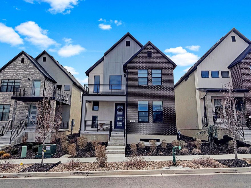 Located in the highly desirable Holbrook Farms community in Lehi, this beautifully maintained single-family home offers the perfect blend of modern, Scandinavian, and traditional design with exceptionally low-maintenance living. The open floor plan features 9-foot ceilings on the main level, a welcoming formal living room, and bright, connected gathering spaces ideal for everyday living and entertaining. The classic white kitchen is both stylish and functional, showcasing quartz countertops, stainless steel appliances, an efficient corner pantry, and a large center island perfect for hosting family and friends. The kitchen flows seamlessly into the dining area and spacious great room, creating a natural hub for gathering. Stylish black metal railings accent the staircase leading upstairs, where you'll find three bedrooms, including a romantic primary retreat with soaring vaulted ceilings and a private outdoor balcony. The spa-inspired primary bath offers a dual vanity, separate tub and shower, and a generous walk-in closet. For added convenience, the laundry room is also located upstairs near the bedrooms. The finished lower level provides a gigantic additional family room and bathroom, with space that could easily accommodate a fourth bedroom if desired. A convenient drop zone just inside the garage provides the perfect place for shoes, coats, and daily essentials. The home is nestled within the 680-acre Holbrook Farms master-planned community featuring a spectacular 33-acre park with a playground, outdoor ping-pong, picnic pavilions, cornhole, off-road cycling trails, sledding hills, multiple pickleball courts, and scenic walking paths. In addition to the main park, a clubhouse, swimming pool, and additional playground are located directly across the street from the home. Perfectly positioned for convenience, this property offers quick access to Thanksgiving Point, Traverse Mountain Outlets, and the Silicon Slopes tech hub. Style, comfort, and thoughtful design come together in this exceptional home, lovingly maintained by the original owners.