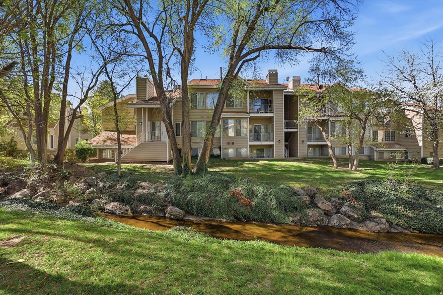 Experience the ultimate in privacy and timeless comfort with this immaculately maintained, main-level condo. Originally the community's model home, this residence offers a classic, intentional layout with distinct rooms that provide a sense of quiet and separation.   The kitchen serves as a charming focal point, featuring a unique red brick oven surround that adds character and warmth.   Tucked away in the community's most private location, your patio and personal garden look directly onto a tranquil river and bridge crossing, framed by hundreds of mature, towering trees.  Inside, you'll find practical upgrades like newer appliances and a cozy gas fireplace. The primary bedroom includes a versatile, sun-filled alcove-perfect for a private library, a dedicated craft space, or a peaceful indoor garden. If you're looking for a move-in-ready home that prioritizes peace, privacy, and traditional charm at an accessible price, this is it.   Note: Square footage figures are courtesy estimates; buyers are advised to obtain independent measurements.