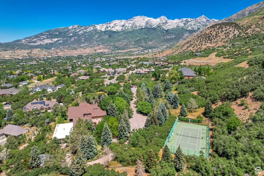 Nestled in the prestigious Holly View Acres, this 7.58-acre estate offers an extraordinary combination of luxury, privacy, and investment potential. Situated on a quiet cul-de-sac, the property is fully gated and fenced, ensuring peace of mind while embracing breathtaking 360-degree mountain views. With four total parcels, this estate presents a rare opportunity to develop, expand, or create a private retreat that backs directly up to US Forest Service Land, preserving privacy and views. The formal living room makes a dramatic first impression, featuring a vaulted ceiling, exposed wood beams, and a luxurious fireplace that serves as the focal point of the space. Expansive windows allow for abundant natural light, highlighting the warmth and elegance of the room. Just beyond, the kitchen is designed for both functionality and entertaining, featuring double wall ovens, a built-in countertop gas range, and a semi-formal dining space. A formal dining room sits adjacent, offering the perfect setting for hosting and entertaining. At the heart of the home, the Great Room boasts a soaring vaulted ceiling, and seamlessly connects to the balcony deck, creating an effortless indoor-outdoor living experience. Enjoy single level living with the Primary Suite on the Main Level, providing a luxurious retreat complete with an oversized shower, jetted soaker tub, and a connecting den with built-in hardwood shelving and workspace for work or relaxation. With 7 bedrooms and 6.5 bathrooms, this home offers abundant space for family and guests alike. Laundry rooms on every level add convenience to daily living, ensuring ease and efficiency throughout the home. The walkout basement is designed for versatility, featuring a full kitchen, designated dining area, and family room with its own separate entrance, making it an ideal mother-in-law apartment, guest suite, or private retreat. The basement is also host to a theater room with stadium seating, making family nights & entertainment at home a breeze. A dedicated wellness and recreation prep area within the basement includes a separate bathroom, shower, Finlandia Sauna, and a Suitmate Swimsuit Water Extractor, ensuring a spa-like retreat after a swim or workout. The indoor heated pool and spa is housed separately from the main residence yet remains easily accessible through the basement entrance. Designed for year-round enjoyment, this space features sliding glass doors around the structure, allowing for an open-air experience when the weather is nice. The surrounding area provides ample room for games, activities, and hosting, making it an entertainer's dream. Stepping outside, the backyard is a paradise for recreation and relaxation, featuring play gyms and equipment for kids, a putting green, a tennis court, and a large greenhouse for homesteading. Whether enjoying outdoor activities or simply taking in the breathtaking scenery, this estate offers an unmatched setting for enjoying the great outdoors. With a stunning paver driveway and oversized 3-car garage with plenty of room for vehicles, toys, and storage, this Estate truly is the perfect blend of practicality and luxury. With its prime location, expansive acreage, and endless amenities, this estate is a rare find in Alpine. Don't miss the opportunity to experience this one-of-a-kind property-schedule a private tour today! Buyer/Buyer's Agent to verify all.