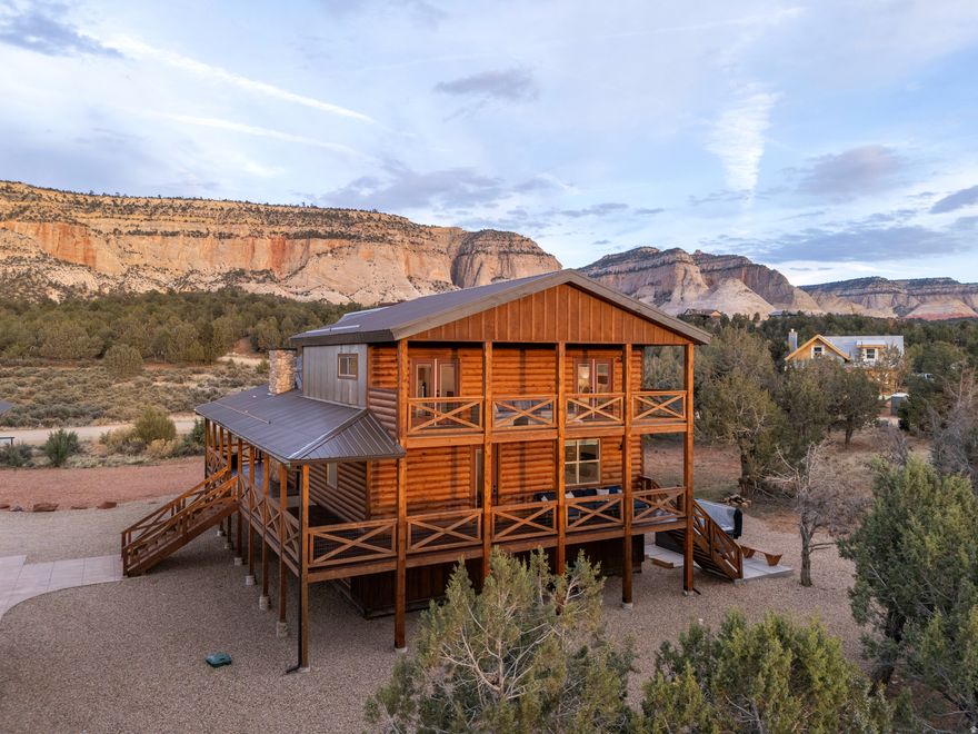 Welcome to your extraordinary vacation retreat and investment opportunity, just a 25-minute drive from Zion. This property features a spacious 5-bedroom, 3.5-bathroom main house, complemented by a separate 2-bedroom, 1-bathroom apartment above the detached garage, both independently rentable for maximum revenue potential. Prepare to be captivated by the stunning surroundings, views of the pink coral cliffs and hay fields in the valley below. Step inside to discover a haven of comfort and style, starting with the expansive great room featuring vaulted ceilings and gas fireplace. The open kitchen, with a large granite island is perfect for hosting family dinners or gatherings of friends. Retreat to the luxurious primary on the main level, boasting a spa-like bath and private access to the outdoors. Downstairs, the basement game room offers additional space to relax, with two bedrooms and a full bath. Upstairs, a loft area features two more bedrooms and another full bath, ensuring plenty of room for everyone to spread out and enjoy. Fully furnished and turnkey ready, this property offers a seamless transition into vacation rental ownership or for those seeking a permanent residence. Buyer to verify all.