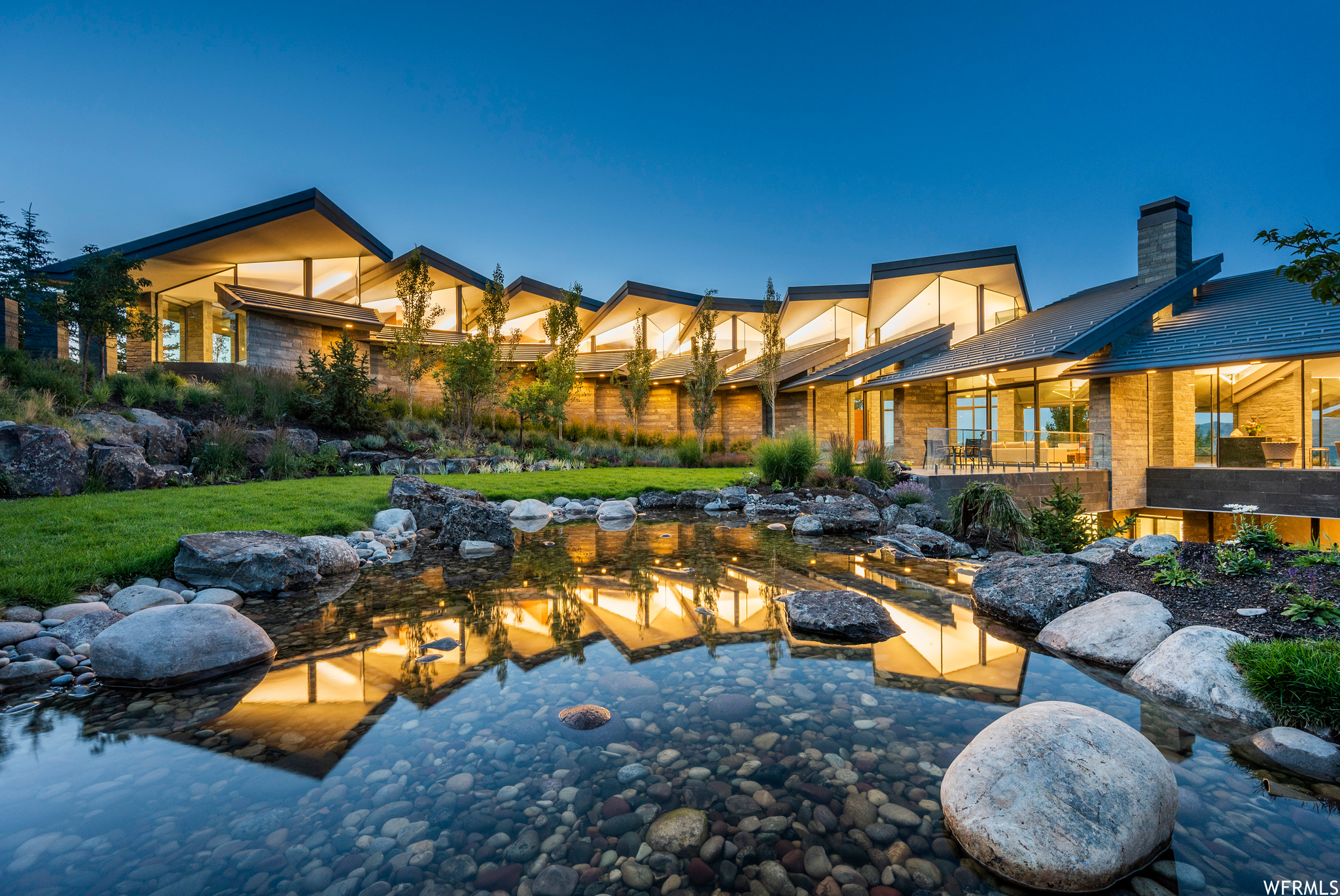 Iconic-Irreplaceable-Impressive. These are just a few words that come to mind when describing this piece of art aptly named Cascade. Designed by world-renowned and internationally recognized designer, Wallace Cunningham, this steel, concrete, glass and stone structure cascades artfully along the mountainside. It sits privately on 5.61 view acres within Promontory and adjacent an available additional 37.12 acre view corridor in Rockport Ranches to protect those amazing views of the Park City mountains. This home is filled with impeccable custom furniture, flawless solid walnut doors, massive sheets of glass for windows, a glass and steel elevator and a stunning floating staircase made of floating walnut. The primary surfaces of the home are all covered in Serpentine Verde stone slabs, that have been brushed for the stone floors, polished for the stone counter tops and cleaved faced for the stone walls. A sunken hot tub with fire features, Savant smart home systems, Venitian plaster walls, and a cascading zinc roof are just a few of the extraordinary ingredients that makeup Cascade. One whole wing of the house is dedicated to the three room Primary Suite which is a sanctuary onto itself and which is guarded by a massive solid walnut door. The Primary Suite is complete with sitting and media areas, a floating fireplace and endless views. The Primary Bathroom features dual bathrooms, dual sinks and dual dressing areas, a glorious shower and a Japanese soaking tub. Three additional guest rooms on the floor below the Primary Suite showcase incredible en-suite light filled bathrooms and jaw dropping views of the surrounding mountains and lake. An adjacent media room and yoga room gracefully flow from one to another. The grand outdoor (heated) terraced patio is large enough to holds hundreds of guests in winter, spring, fall and summer. This incredible outdoor space has fire features and mesmerizing vistas of mountains and water. All of this is surrounded by a boulder encrusted waterfall and a meandering granite block stream.   Come, Experience Cascade.