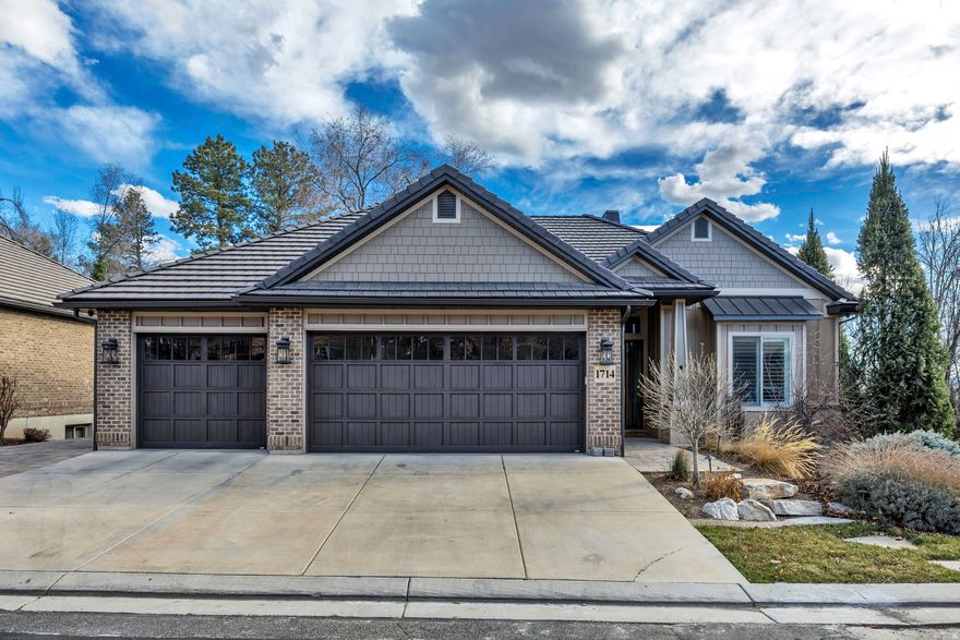 This gated, timeless home in the heart of Holladay is filled with natural light, soaring 12-foot ceilings, quality finishes, and high-end features throughout. The main level is designed for effortless living, featuring a main-floor primary suite and open gathering spaces ideal for both everyday living and entertaining. The lower level offers 10-foot ceilings and over 3,000 square feet of finished living space, including a fully equipped gym, a future golf simulator setup, wet bar, generous storage, and flexible space to fit your needs. Step onto the covered deck and take in peaceful, tree-lined views with no backyard neighbors that offers a level of privacy that's hard to find. Designed as a true extension of the home, the outdoor living space functions as a second family room, perfect for year-round enjoyment. Located within a gated community just off Highland Drive, this home offers an ideal balance of privacy and convenience. Enjoy quick freeway access with easy connectivity to downtown Salt Lake City, SLC  International Airport, and the nearby Big and Little Cottonwood Canyons, as well as Parleys Canyon, providing year-round access to skiing, hiking, and outdoor recreation.