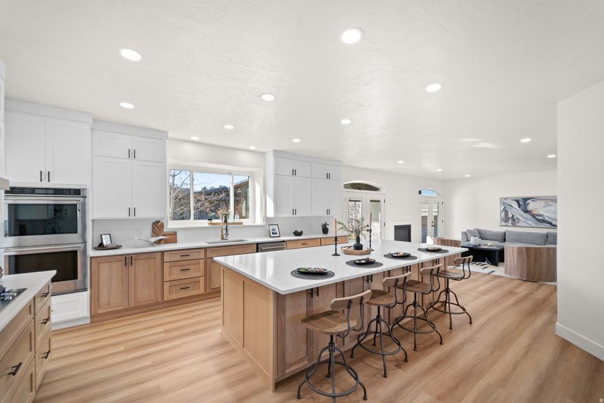 Welcome to an extraordinary modern-farmhouse residence, masterfully reimagined with sweeping views of the Wasatch Mountains. Completely remodeled with uncompromising attention to detail, this home showcases refined craftsmanship, timeless design, and resort-level amenities at every turn. A sweeping wraparound covered front porch sets a gracious tone, offering a front-row seat to peaceful mornings and unforgettable mountain sunsets. Inside, the home unfolds into light-filled living spaces anchored by a striking living room with oversized new windows, creating an atmosphere of warmth, elegance, and effortless comfort. The heart of the home is the chef's kitchen-designed to impress and perform-featuring custom two-tone cabinetry, quartz countertops, a grand statement island, pot filler, double ovens, stainless steel appliances, and abundant storage. Updated LED lighting throughout enhances the home's clean lines and sophisticated finishes. The primary suite is a true private retreat, offering generous space, automatic blinds, and a grand custom bathroom suite complete with glass-enclosed shower doors, upscale finishes, and an expansive walk-in closet designed for luxury living. Outdoors, the property transforms into a private resort. A newly constructed heated in-ground saltwater pool with cascading waterfall features and multi-level lounging areas creates a stunning focal point, complemented by a chic pool house ideal for entertaining or relaxing. Two covered decks provide ample space for gatherings, while low-maintenance turf grass, an in-ground trampoline, and a private basketball court with custom lighting elevate both form and function. Zoned for horses, this property offers a rare opportunity to blend refined living with equestrian potential, adding versatility and long-term value to an already exceptional setting. For the collector, entrepreneur, or enthusiast, the impressive 15-car heated and air-conditioned garage and shop is unparalleled, featuring massive automatic doors and expansive concrete space ideal for oversized vehicles, business use, or luxury storage.Garage measures 100 feet long, 32 feet wide, and approximately 17 feet high, and features 14-foot doors. Additional RV parking adds further versatility. This is more than a home-it is a lifestyle property where modern sophistication meets refined rural charm. Every element has been thoughtfully curated to offer privacy, luxury, and enduring value in a setting that is as functional as it is breathtaking.   Square footage figures are provided as a courtesy estimate only and were obtained from county record. Buyer is advised to obtain an independent measurement.