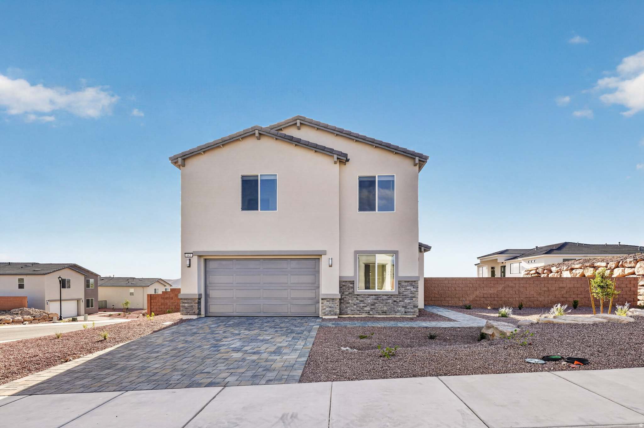 Contemporary two-story residence featuring a stucco exterior and stone facade accents