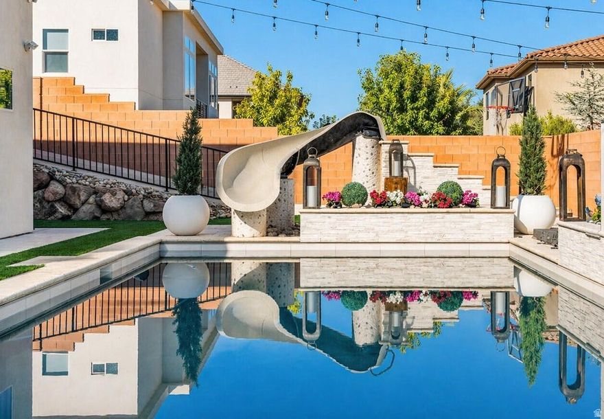 Step into elevated living with this beautifully upgraded home, thoughtfully designed to deliver luxury, comfort, and unforgettable indoor-outdoor entertaining, all situated on an expansive .29-acre lot in a desirable community. The true showstopper is the dream backyard, perfectly north-facing and built for year-round enjoyment with a stunning pool featuring a waterfall, slide, fire pit, kiddy pool with bubblers, separate hot tub, and pool cover. The outdoor experience is elevated even further with a fully equipped kitchen boasting gorgeous porcelain countertops, a built-in BBQ and pizza oven, plus a Terrace TV and Sonos sound system that creates an incredible atmosphere throughout the entire pool area. Inside, the main kitchen is equally impressive with a fully upgraded pantry and premium Thermador appliances, while the spacious primary suite offers a luxurious retreat complete with a custom Classy Closet system. Additional highlights include upgraded flooring and designer lighting throughout, a dedicated home theater room, and a fully finished basement with a second kitchen, laundry closet, and brand-new LVP flooring, perfect for guests or multi-generational living. The oversized 3-car garage is loaded with upgrades including epoxy floors, enhanced LED lighting, a built-in safe, and both electric and gas water heaters, all complemented by generous RV and toy parking for ultimate convenience. Buyer to verify all information, deemed reliable, however buyer to verify all info including utilities, rental restrictions, and HOA information if applicable.