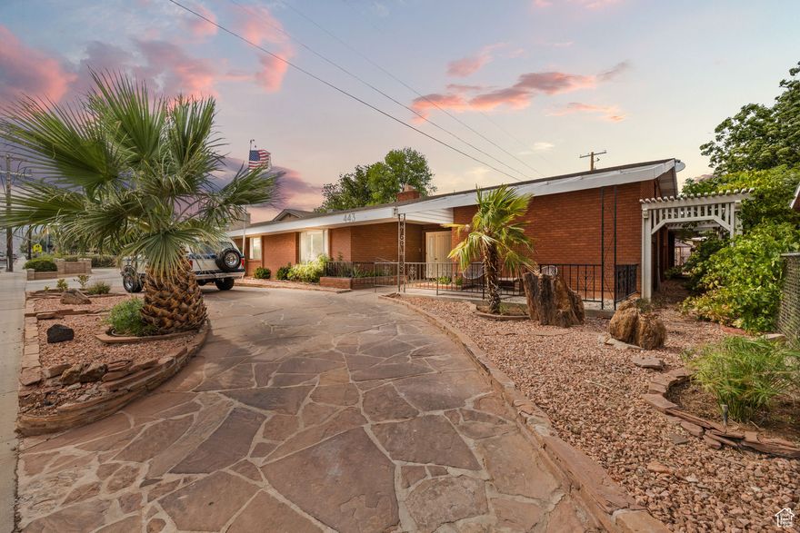 Retro Rambler | Built in 1972 and still bringing the charm, this classic brick beauty sits right in the heart of St. George. Inside you'll find 4 bedrooms plus a bonus 5th room or potential casita with its own entrance, perfect for guests, a home office, or that moody teenager. The inside got a full glow-up! New kitchen top to bottom! All new appliances, engineered hardwood flooring, carpet, tile & fixtures, but we kept the character. Think of it as a facelift with soul. The large & charming backyard has raised garden beds, a greenhouse, and plenty of room to roam.  Just 2 miles from Utah Tech and walking distance to schools, parks, and shopping. No HOA, but a whole lotta charm and all the modern updates where it counts.