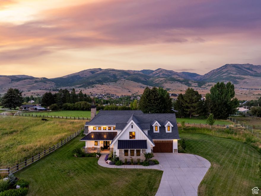 This 5-bedroom, 5-bathroom custom home delivers 6,390 square feet of living space on just under one acre inside Elk Ridge Estates, a three-member HOA in Liberty on the northwest farmlands of Ogden Valley. It is the first property ever offered to the public in this exclusive neighborhood and enjoys clear mountain views and protected open spaces. The location strikes a rare balance between country-quiet and city-convenience. I-15 and downtown Ogden lie about twenty minutes away, and Salt Lake City International Airport is roughly an hour south. Year round recreation surrounds you with North Fork Park, Powder Mountain, and Pineview Reservoir only minutes from the front door. A vaulted great room commands attention with exposed timbers, a full height stone hearth, and both wood burning and gas fireplaces. The chef level kitchen pairs white cabinetry, statement tile, professional grade appliances, designer lighting, and premium plumbing fixtures around an island that seats four. The main level primary suite offers vaulted ceilings, generous natural light, a spa style bath, and a large walk in closet. Half bath including dog wash station. Upstairs, three additional bedrooms join a flexible bonus room and a dedicated office. Downstairs one bedroom and one full bath. Practical features include an oversized pantry, a full mudroom, a built in desk nook, extensive storage, and a secure vaulted safe. Landscaping frames the home with flat lawn space while uninterrupted Wasatch views stretch beyond the property line. Elk Ridge Estates preserves the surrounding open space, ensuring long term privacy and an unparalleled sense of place. All property information, boundaries and documents to be verified by buyer.
