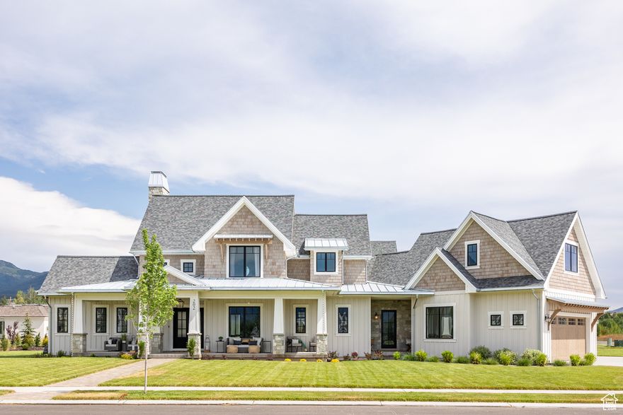 Nestled in the picturesque Saddle Creek Midway development, this 2024 Park City Showcase of Homes is a stunning Cape Cod-inspired retreat that seamlessly blends vacation-style amenities with everyday luxury living. Set on half an acre with breathtaking views of Mount Timpanogos and the Wasatch Range, this 6-bedroom, 6-bath home offers a refined yet functional layout. The light-filled interior boasts exquisite finishes, including hardwood floors, marble, tile, and plush carpeting. A gourmet kitchen with high-end Thermador appliances and quartz countertops opens to a covered patio with a built-in BBQ-perfect for entertaining. The guest suites, thoughtfully designed on both the upper and lower levels, provide a serene retreat with a perfect balance of privacy and warmth.  The lower level surprises with unique amenities, including a children's playhouse, a sauna and cold plunge, two game areas, and a ventilated barn wood-paneled safe and vault room. Additional highlights include three laundry areas, a three-car heated garage, and a mudroom with custom cabinetry. A private guest apartment on the second floor features its own kitchen, washer/dryer, and essential appliances-ideal for extended stays. Outdoor spaces invite relaxation, while the Saddle Creek Midway community offers walkways, greenbelts, and play areas. With its proximity to Provo Canyon, Midway's charming Center Street, and Heber Valley's world-class amenities, this home is more than a residence-it's a retreat to savor. Schedule your visit today!