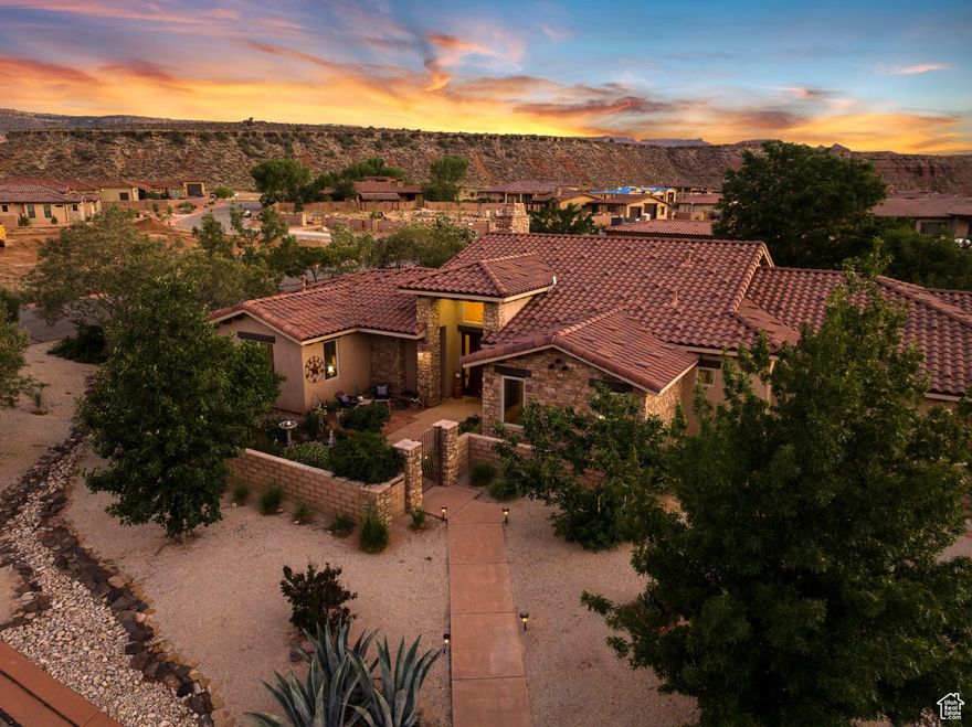 Nestled on over half an acre in the charming town of Virgin, Utah-just moments from the splendor of Zion Canyon-this custom-built residence offers a refined blend of indoor comfort and outdoor beauty.  Beyond the private gate, a landscape of fruit and nut trees, raised garden beds, and curated desert flora invites you to slow down and savor the seasons. Whether you're harvesting fresh figs for a summer tart or gathering herbs for a winter roast, the land here is as purposeful as it is picturesque.  Inside, the 2,466-square-foot floor plan is graciously laid out, featuring three spacious bedrooms and three bathrooms-including two generous primary suites designed for rest and rejuvenation. High ceilings, natural light, and quality finishes throughout create a warm, welcoming atmosphere perfect for both quiet evenings and festive gatherings.  The oversized garage including a separate workspace and storage room, provides ample space for storage and hobbies, while the nearby trails and canyons offer endless opportunities for exploration. Whether you're preparing fresh pasta in the well-appointed kitchen or enjoying morning tea on the patio with views of red rock cliffs, every moment in this home is a celebration of comfort, style, and simple pleasures.