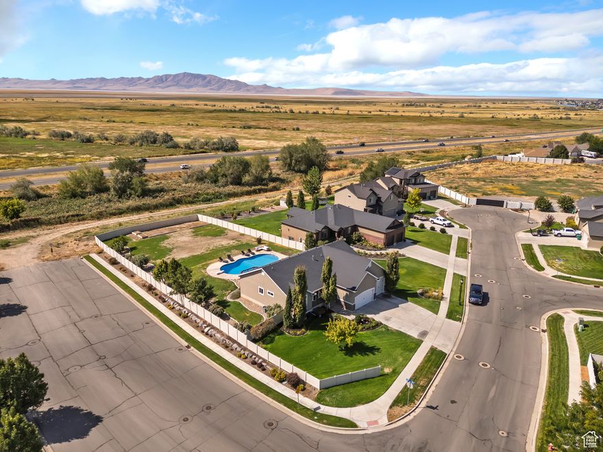 Enjoy unobstructed mountain views and no backyard neighbors in this beautifully maintained Layton home, complete with a brand-new 2025 pool and hot tub. The inviting main level features a wide entry, gas fireplace, large south-facing windows, and vaulted ceilings that fill the space with natural light. The kitchen offers a gas range, refrigerator, large pantry, and laminate floors, with a separate dining area for gatherings.  The generous primary suite fits a king bed with room to spare and includes bay windows, dual vanity with defogging mirror, separate tub/shower, and custom closet organizers. Secondary bedrooms are equally spacious with ceiling fan/light combos and shared finishes for a cohesive look. The mudroom includes lockers, laundry, and access to a rare 4-car finished garage with tall ceilings, dog doors, and negotiable workbench.  The basement adds flexibility with a 4th bedroom, large windows, 9' ceilings, a family room, and framed spaces ready to finish with upgraded electrical and canned lighting.  Exit outside to a backyard designed for both relaxation and entertaining: a redwood deck, fruit trees (2 apple, 1 peach), garden beds with drip irrigation, decorative curbing, fountain, and 16-zone sprinklers. The pool features variable-speed pump technology to save on costs, and all pool equipment is included.  Smart-home features like Google Home automation, Nest thermostat and doorbell add convenience and peace of mind. **Showings unavailable until the Open House on Friday, October 3rd from 4- 7pm**