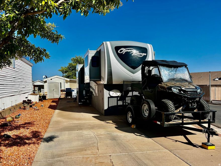 Come one, come all and see this beautiful lot located across from the pool and clubhouse. The spacious lot features a lovely, decorated side yard and includes a shed. Also included in the purchase is a 2018 Open Range by Highland Ridge fifth wheel featuring five slides, dual A/C units, double refrigerator, kitchen island with sink, king-size rear bed, step-in shower, washer/dryer hookups, fireplace, vinyl plank flooring, sliding hitch, and storage under the gooseneck. Enjoy the 60-inch TV and comfortable swivel recliners. Buyer to verify all information