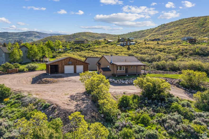 Wide open spaces and sweeping views await you at this exceptional 2 bedroom, 2 bath home, nestled on a spacious .87 acre lot. Designed with comfort and efficiency in mind, this home makes every square foot count. Tall ceilings and expansive windows frame breathtaking panoramic views from the front porch, creating a stunning connection to the outdoors. The inviting interior offers a warm, open feel, while the fenced grassy area provides a secure space for pets, play, or gardening. A large oversized garage, dedicated workshop, and separate out building give you all the room you need for hobbies (including amperage for welding), storage, and projects. The property boasts a huge RV parking area complete with hookups. The unfinished basement holds untapped potential, offering even more room to grow and customize to your needs. Whether you're soaking in the unbeatable views from the porch, working on your latest project, or planning your next adventure, this property offers the perfect blend of comfort, flexibility, and breathtaking natural beauty. This property is more than a home, it's a unique retreat to dream and grow.