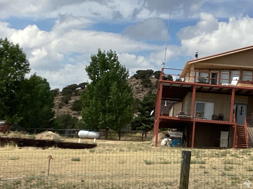 This home is ALL about the ENORMOUS DECK and the VIEWS OF FOREVER, in about 320 degrees!  The deck is partially covered by the overhang of the house.  No flooring and two bedrooms and the working bath downstairs need completion.  Large garage underneath the living area provides the priceless living views!  2 covered carports are large.  Wood burning stove as well as a furnace.  There is an elevator inside the garage.  This house needs a little TLC and finishes, but offers EVERYTHING!  On 1 acre lot on Washam (no property tax) side of Manila. These homes don't come on market often.