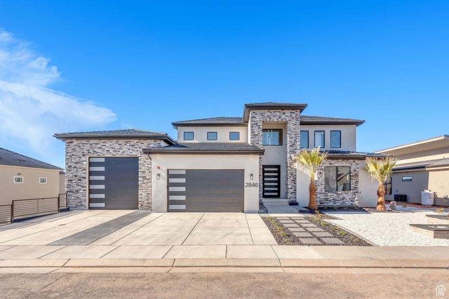 This newly built custom home seamlessly blends modern and rustic  styling as you open the large custom pivot door into the entry with lofty ceilings, modern fixtures and rustic wood accent wall on the towering fireplace in the great room. The large kitchen with hidden pantry, built in ice maker, full size side-by-side fridge and freezer and two dishwashers makes it great for entertaining. A set of double sliding doors on the main level open the great room up to a large deck with hot tub where you can take in the sunset or overlook the backyard featuring a pool and hot tub, outdoor fire pit with built in seating, putting green, pool bathroom, and outdoor kitchen area. Full daylight walkout basement with 10' ceilings also features double sliding doors out to the covered patio, making the transition from indoor to outdoor living effortless. Back inside you'll find 5 primary style bedrooms each containing en suite bathrooms. Two additional bedrooms on the upper level have built in bunk beds. The garages offer storage space for all your toys- with an RV garage on a suspended slab and extra garage underneath. RV garage also features a condensed pickleball court and basketball standard. House is just a 5 minute drive to Sand Hollow Reservoir. 3 minute walk from all-abilities park with dog park and pickleball courts. Whether you are looking for a vacation home or to feel like you're on vacation at home, this custom home was designed for you.  Furnishings and household goods are negotiable and may be added with a separate bill of sale for $120,000 making this home turn-key.  Listing agent is related to seller.