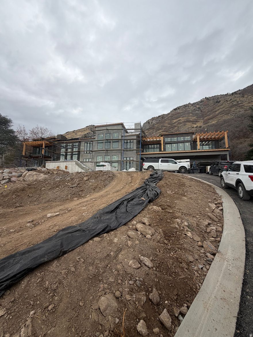 Perched on a private end lot on Provo's coveted East Bench, this luxury new-construction residence offers a rare blend of total privacy, dramatic mountain backdrops, and sweeping valley views of Utah Lake. With no neighbors and unobstructed sightlines, the home feels like a secluded retreat while remaining minutes from the heart of Provo. Designed with refined elegance and thoughtful craftsmanship, this exceptional spec build showcases elevated finishes, expansive windows that frame the Wasatch Mountains, and seamless indoor-outdoor living that captures sunrise over the peaks and sunset across the valley. The private lot provides a tranquil setting ideal for entertaining or quiet relaxation, all while enjoying panoramic views that stretch from the foothills to the lake below. From its premier East Bench location to its rare end-lot privacy and breathtaking scenery, this home represents a truly one-of-a-kind opportunity to own a luxury mountain-view residence with unmatched valley vistas in one of Provo's most desirable neighborhoods.  Home has an elevator for ease of 1st to 2nd floor living