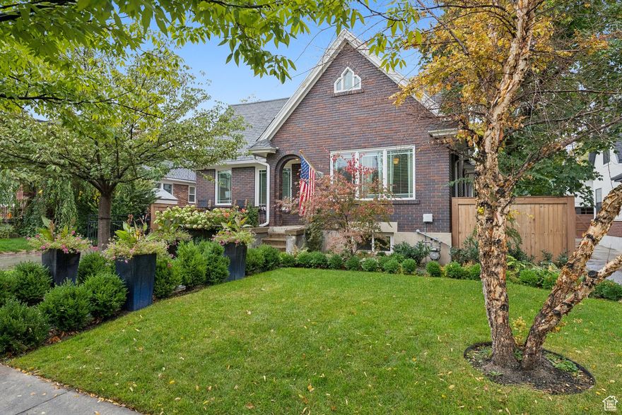 Welcome to the storybook charm of Yalecrest! This delightful 1928 Tudor beautifully combines timeless character with thoughtful updates. Step inside and you'll find a welcoming formal living room with a traditional wood-burning fireplace and cove ceilings. The primary suite is complete with a walk-in closet and sitting area. The bright, updated kitchen with a spacious dining area, is perfect for gathering. The main level also offers a family room for relaxed everyday living. Upstairs, you'll love the versatile loft, which doubles as a second primary suite with its own en-suite bath and walk-in closet. The finished basement adds even more flexibility with 3 more bedrooms, a complete kitchen, separate laundry, and full bath - ideal for guests, extended family, or income potential with its mother-in-law setup. Step outside to your backyard oasis, designed for entertaining. A covered pavilion, built-in gas fire pit, stainless steel grill, granite counters, and a brand-new Belgard paver patio, walkways, and driveway make this space as functional as it is beautiful. A custom-built detached garage with 240-volt wiring is the cherry on top. Don't miss your chance to own this charming piece of Yalecrest history!
