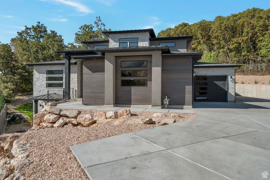 Modern Two Story Home Loaded with Upgrades! This stunning modern home in South Ogden offers a functional layout with stylish finishes throughout. The spacious Great Room flows seamlessly into the Kitchen, where a full window wall and sliding glass doors open to a beautiful outdoor patio-perfect for indoor/outdoor living and entertaining. Enjoy sleek, modern designs, upgraded kitchen finishes, and a large walk-in pantry. The main laundry room is conveniently connected to the mudroom just off the garage.The Primary Suite is a true retreat, featuring a separate tub and shower, plus in-suite laundry hookups located in the large walk-in closet. Downstairs, you'll find a second Primary-like suite with its own walk-in closet and private laundry hookups-ideal for guests or multi-generational living.The lower-level living room includes a kitchenette and two separate entries-one of which is a private entrance perfect for a home office/business. Additional highlights: 3-car garage with an extra-deep 3rd bay,RV parking along the side of the garage. Terraced backyard with a lovely patio space, Home is nearly finished; Certificate of Occupancy expected in ~30 days, Don't miss your chance to own this feature-rich, move-in-ready modern home!