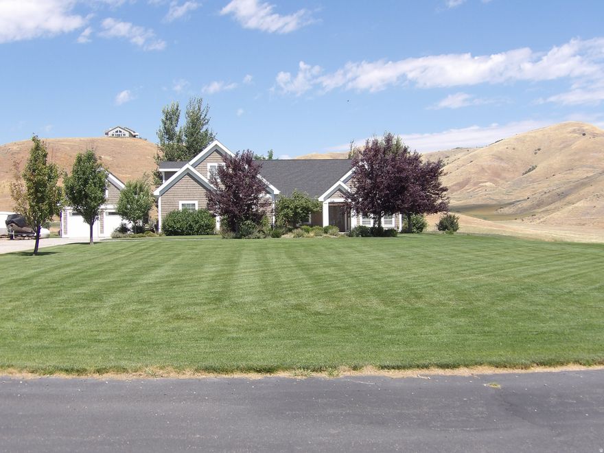 Welcome to lake living at its best! This charming Cape Cod-style home sits in a gated community and offers 3 bedrooms, 2.5 baths, and stunning mountain and lake views. Inside, you'll love the bright open layout, vaulted ceilings with exposed beams, cozy fireplace, and a beautiful kitchen with a large island made for gatherings. Big windows fill the home with natural light, while the spacious yard gives you room to relax and enjoy the peaceful surroundings. This is the perfect blend of comfort, style and location. Come see it for yourself!