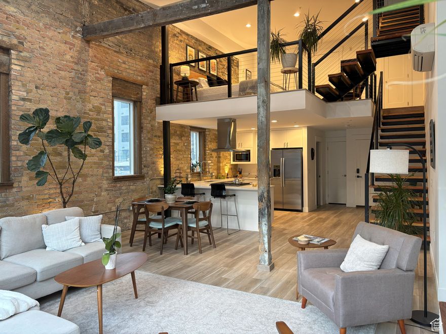 This is a rare turn-key opportunity. Offered fully furnished with curated pieces that perfectly complement the industrial-chic aesthetic. Recently renovated in 2024. Zoned D1, possibly allows for short-term rentals, this unit presents a compelling opportunity-whether you're seeking a high-end investment property or a personal downtown retreat. This one-of-a-kind, luxury loft is unlike anything else in the city-boasting a bold, open layout that's both visually striking and functionally smart. Spanning three dramatic levels, this industrial-chic space is packed with design-forward features: exposed brick, original wood beams, and soaring 22' ceilings (stretching up to 32' as the staircase winds through the levels). Massive 9x9 city-facing windows flood the space with natural light and serve up stunning views of the vibrant downtown streetscape below. The main floor is made for entertaining, with a sleek kitchen, open-concept living/dining area, and a convenient guest bath. Upstairs, a mezzanine flex space makes the perfect second bedroom, home office, or creative studio, while the third level offers a spacious and private primary suite, full bath, and laundry. Top it all off with your very own 400 sq ft rooftop deck-wired and ready for a hot tub, or simply a dreamy spot to unwind with friends, cocktails, and sunsets. Perfectly situated in a quiet alley between 200 and 300 South, you're steps from the best of Salt Lake's nightlife, food, theaters and more. Plus you're minutes aways from shopping, a full-service grocery store, gym, convention center and everything else downtown has to offer. Don't forget just a quick drive to world-class ski resorts and endless outdoor recreation-from mountain trails to powder days, it's all within reach. This is urban living redefined: bold design, unbeatable location, and unmatched downtown energy. Don't miss your shot to own this truly rare, luxury boutique loft in the heart of it all.