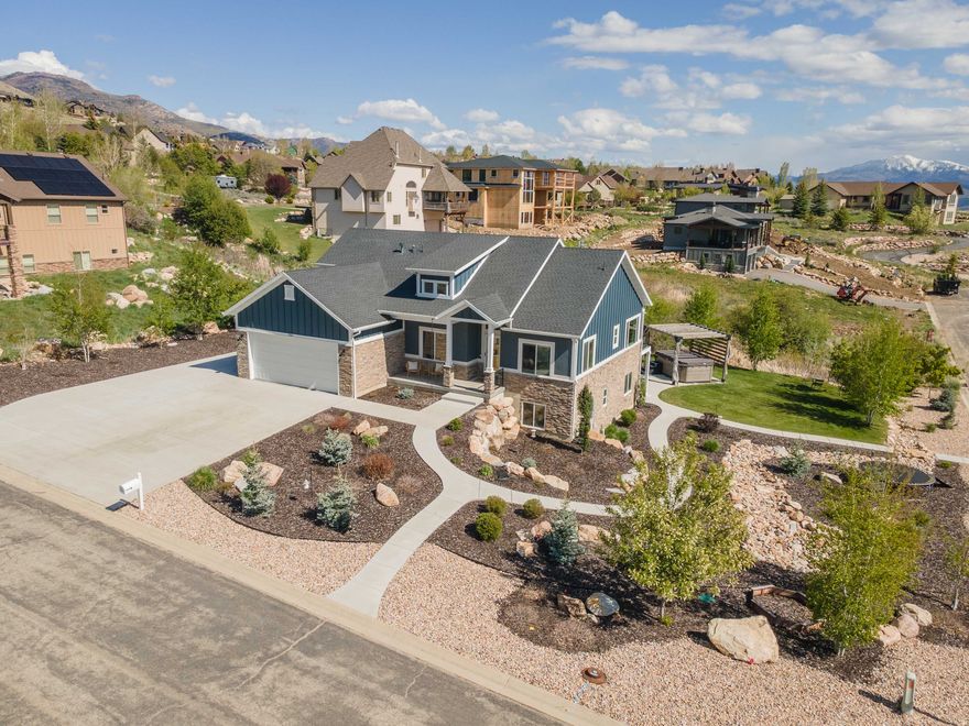 Enjoy breathtaking Snowbasin views from the covered deck of this beautifully designed Ogden Valley home, perfectly positioned across from Wolf Creek Golf Course and just minutes from Powder Mountain. Walking distance to Powder mountain bus stop. Filled with incredible natural light, the home captures the best of Utah's mountain lifestyle in every season. The thoughtfully designed floor plan offers true main-level living with the primary suite, office, and spacious living areas all on the main floor. At the center of the home, the kitchen features a stunning waterfall-edge island ideal for gathering and entertaining. The walk-out basement provides excellent flexibility and includes a dedicated home gym, guest space potential, and easy access to the landscaped backyard. Outside, enjoy a finished zeroscape yard with a peaceful stream, nearby walking trails, and RV parking for added convenience. Turnkey and low-maintenance, this home offers effortless access to skiing, golf, trails, and year-round recreation-an exceptional opportunity to live the dreamy Ogden Valley lifestyle close to everything outdoors.