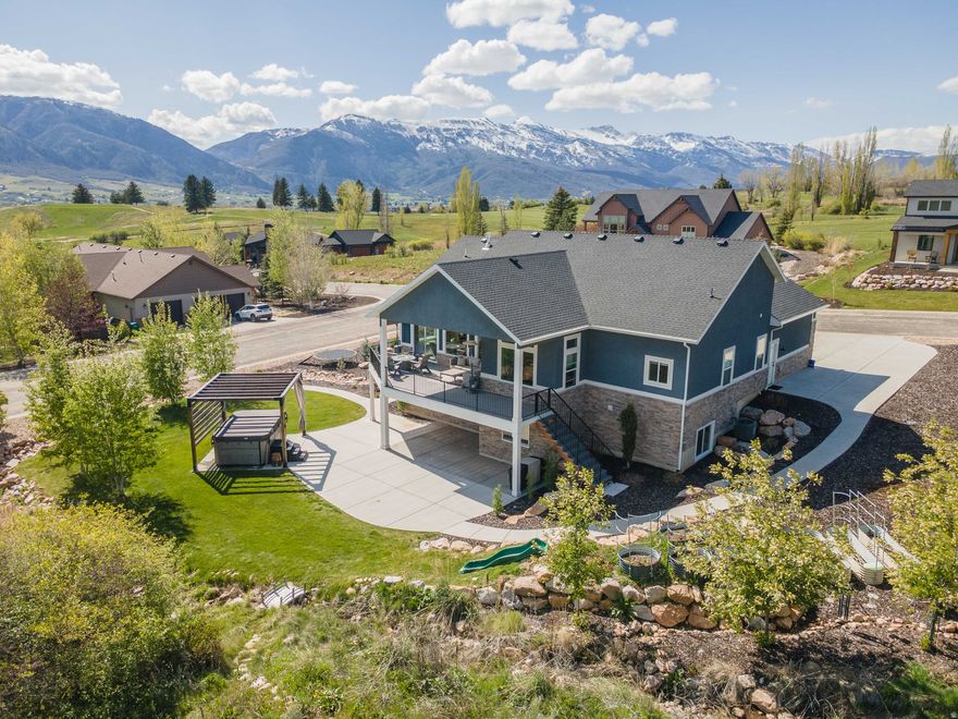 Enjoy breathtaking Snowbasin views from the covered deck of this beautifully designed Ogden Valley home, perfectly positioned across from Wolf Creek Golf Course and just minutes from Powder Mountain. Filled with incredible natural light, the home captures the best of Utah's mountain lifestyle in every season. The thoughtfully designed floor plan offers true main-level living with the primary suite, office, and spacious living areas all on the main floor. At the center of the home, the kitchen features a stunning waterfall-edge island ideal for gathering and entertaining. The walk-out basement provides excellent flexibility and includes a dedicated home gym, guest space potential, and easy access to the landscaped backyard. Outside, enjoy a finished zeroscape yard with a peaceful stream, nearby walking trails, and RV parking for added convenience. Turnkey and low-maintenance, this home offers effortless access to skiing, golf, trails, and year-round recreation-an exceptional opportunity to live the dreamy Ogden Valley lifestyle close to everything outdoors.