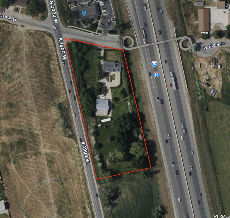 SELLER MOTIVATED! BIG PRICE DROP! Easy access to 1-15/I-84 and has 533 FEET OF FRONTAGE! along 2000 W. DO NOT DISTURB CURRENT OCCUPANTS OF PROPERTY. Property is master planned for commercial. Sandwiched between I-15 and 2000 W (UT-84) just South of the Pioneer Rd (400 N) Exit ramp of I-15. Currently there is a residential two-story home on the lot. Culinary water is provided by Bona Vista. Irrigation water is supplied by North Slaterville Irrigation Co (4 shares). Power and Gas connected to residence. Residence is on Septic. Contact agent for more information. AGENT IS RELATED TO SELLER.