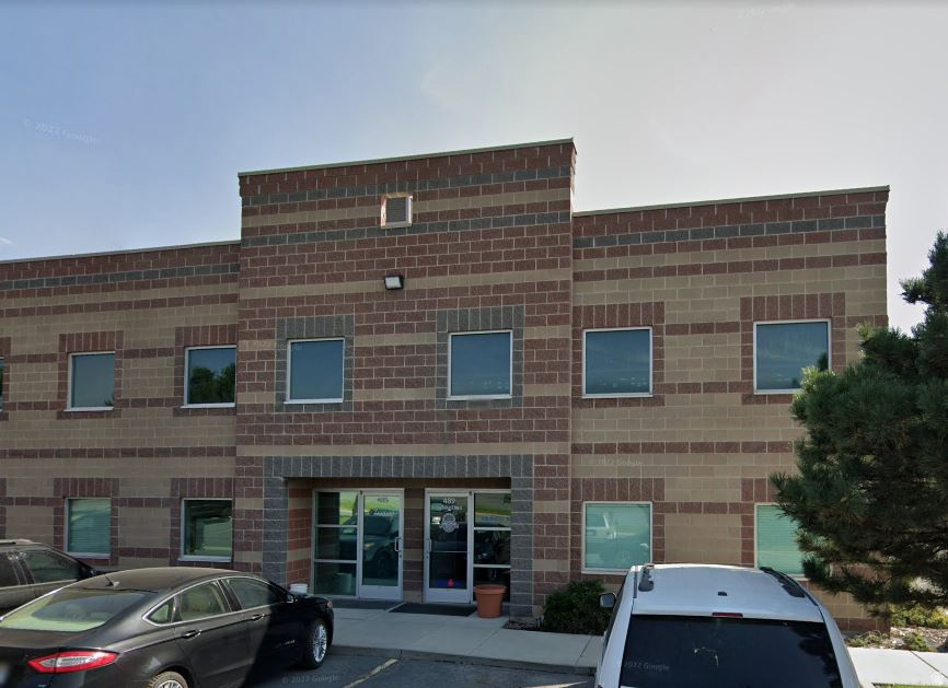 Two-story brick building featuring a prominent central entrance and multiple window openings