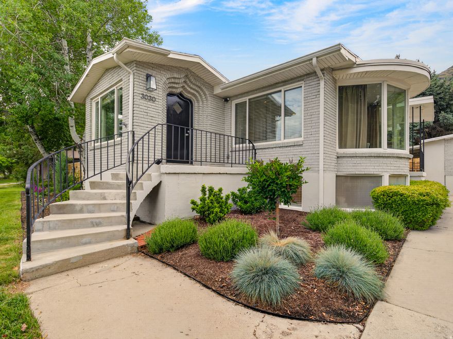 Located in the popular Indian Hills neighborhood of East Provo, this beautifully updated 6-bedroom home features a complete interior remodel completed in 2022/2023, including an expanded primary suite with enlarged dual closets and a spacious ensuite bathroom. The custom kitchen has quartz countertops, soft-close cabinetry, tile backsplash, and updated finishes throughout. Additional upgrades include new LVP flooring, updated trim, doors, baseboards, fresh interior paint, a new HVAC system (2022), electrical panel upgrade (2023), Level 2 EV charger, built-in garage storage, and a roof replaced in 2017. The home is filled with architectural charm, including custom arched openings, distinctive brick entry work, a unique front door, and a professionally commissioned entry mural completed in 2026. Outside, enjoy a fully redesigned backyard landscaping project completed in 2024, featuring mature trees and multiple private outdoor entertaining spaces. Recent sewer scope and radon testing were both completed with no issues. Ideally located within walking distance to the Rock Canyon Trailhead and just minutes from BYU, Timpview High School, Centennial Middle School, and Rock Canyon Elementary.