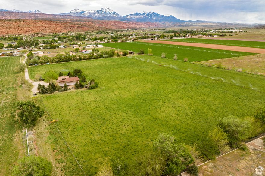 A DEVELOPERS DREAM! Here is an exceptional opportunity to own a prime 15.58-acre lot with incredible development potential! This expansive property offers a blend of natural beauty and modern convenience. Access is easily established from Brooks Drive, ensuring seamless integration for future projects. Envision a residential community, a resort-style retreat, or an agricultural venture - the canvas is yours to shape.  This property also includes a 2957-square-foot main home, casita, and shop that can be used while completing your project. Every detail in the main residence has been meticulously crafted to create a space that exudes both comfort and style. At the heart of this home, you will find 3 spacious bedrooms, 3.5 baths, a grand entry, and a great room with a custom masonry fireplace, where you can indulge in the panoramic views of the majestic La Sal Mountains paired with the unforgettable views of the Moab rim, providing a picturesque backdrop of where the mountains meet the desert. A modern southwest feel encompasses the estate with vaulted tongue and groove pine ceilings, raw wood beams, fir hardwood floors, and knotty alder cabinets. For additional guests, the property includes a delightful separate studio casita. This cozy space offers a private living area with comfortable sleeping quarters, fully equipped kitchenette, and a modern bathroom. A versatile shop is also included on the property, providing lots of space for creative endeavors, storage, or workshop projects. Square footage figures are provided as a courtesy estimate only and were obtained from images.  Buyer is advised to obtain an independent measurement.