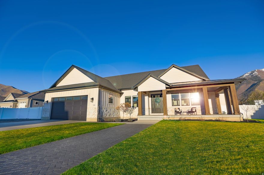 The pinnacle of craftsmanship, this custom palatial rambler offers striking finishes on .83 acre of horse property, with a wraparound covered corner porch. Experience unrivaled luxury where no expense was spared, set on a quiet street with unobstructed views of Maple Mountain and no back neighbors--ever. Inside, over $150,000 in custom solid oak, walnut, and painted cabinetry anchors the home, complemented by a main floor double island and shiplapped tray ceilings with custom beams. Designed for multi-generational living, the home features two full kitchens with black stainless steel appliances and oversized stunning quartz  counters. The structural upgrades are equally impressive: blown-in high-density cellulose in the joists, the thickest luxury LVP flooring on the market, and a full basement with its own zoned HVAC and soundproofing. A fifth flex den/bedroom off the entry foyer. The extra-deep/wide garage easily accommodates two long-bed trucks with room to spare with extra height, depth, and width--and with plenty of room for a three or 4 car addition. Outside, enjoy $35,000 in epoxy patios and over 2,000 sq. ft. of covered entertainment space, complete with hot/cold exterior spigots, a hot tub hookup, and pressurized irrigation. This is Mapleton living without compromise. Make it yours today!