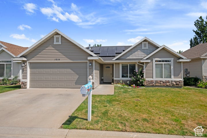 Single-story residence featuring light gray siding, a two-car garage, and a concrete driveway