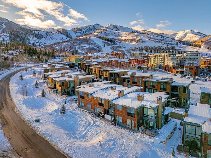 This well-maintained Canyons Village townhome offers the rare combination of ski-in access, walkable proximity to the new lift, and a turn-key interior that feels like new.       Designed for easy ownership and resort use, the home works well as a personal mountain residence, vacation property, or nightly rental. The downhill floor plan creates a clear separation among the main living area, private bedroom suites, and the lower-level gathering space.       The main level is bright and open, with vaulted ceilings, large windows, and views toward Iron Mountain. The great room opens to a private deck with a hot tub, creating a comfortable place to unwind after skiing, biking, hiking, or golf. The kitchen and dining areas are designed for hosting, with quality finishes and a clean mountain-modern feel.       Upstairs, three-bedroom suites offer privacy, comfort, and generous closet space. A landing office nook adds a practical workspace with mountain views. The lower level expands the home's flexibility by adding a second family room for movies, games, or additional gathering space, along with an oversized bunk room that serves as the fourth suite.       The home has been maintained as new and improved with designer-selected furnishings, a home management system, automatic blinds, built-in closet storage, and other behind-the-scenes upgrades that make ownership easier. A two-car garage and large mudroom provide the storage needed for skis, bikes, golf gear, and year-round Park City equipment.       Located in Canyons Village at Park City Mountain Resort, the property is close to skiing, golf, biking trails, restaurants, shops, and resort amenities. The home offers ski-in convenience, shuttle service, and walkable access to the new lift, with Park City's historic Main Street approximately 10 minutes away.       Contact your agent for details about this Canyons Village ski property.