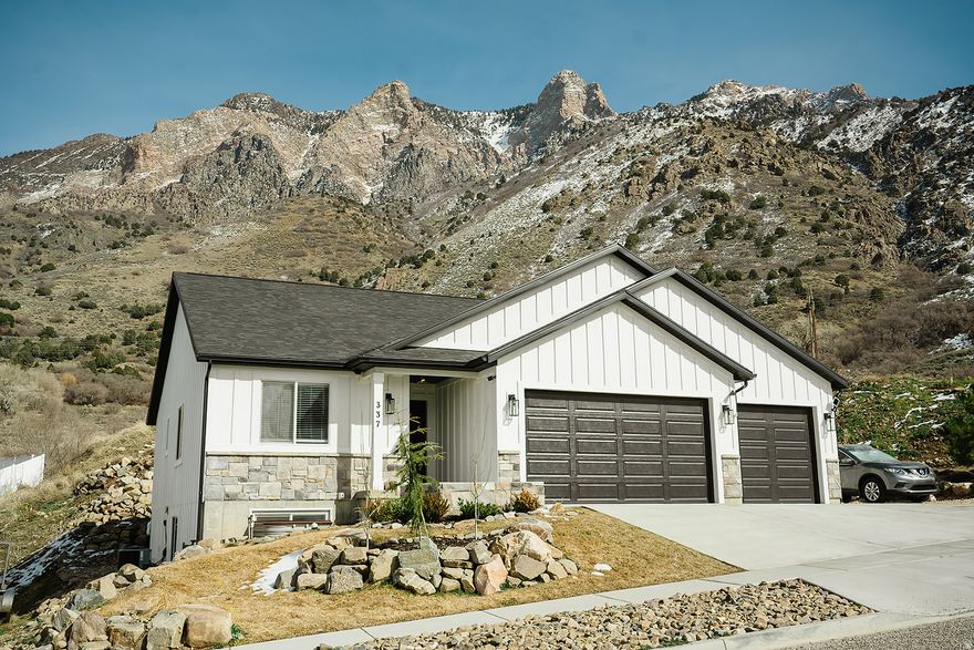 HUGE PRICE REDUCTION! Have the mountains right in your back yard while overlooking Willard Bay! Awesome neighborhood on a dead-end street.  This home was built in 2024 and still looks brand new! Fun angles and nice neutral paint.  Beautiful kitchen with granite countertops, soft close cabinets and a huge island! Large windows to take in the beautiful mountain view! The 2nd kitchenette and laundry room downstairs are perfect for convenience or multigenerational families. All appliances stay, including upstairs washer and dryer. Double vanity in the master bathroom and a large walk in closet. The 4-car garage is huge and even has a half bath in it! It also has a EV charger and 2 extra garage door on the side as well as double doors in the back, making it easy to access your car, your toys, lawn mower, etc. This home truly is one of a kind.  Nice neighborhood with hiking trails and waterfalls within 5 minutes. Schedule your showing today!