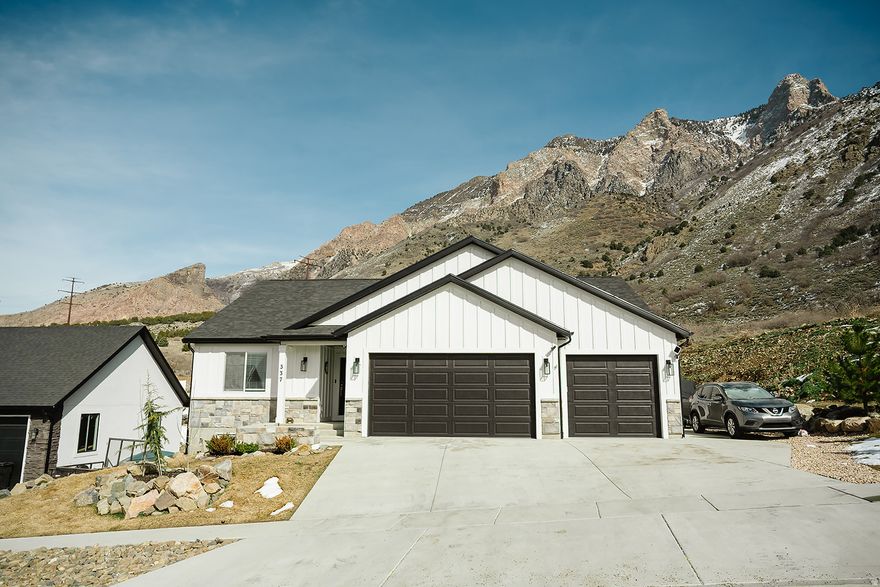 HUGE PRICE REDUCTION! Have the mountains right in your back yard while overlooking Willard Bay! Awesome neighborhood on a dead-end street.  This home was built in 2024 and still looks brand new! Fun angles and nice neutral paint.  Beautiful kitchen with granite countertops, soft close cabinets and drawers and a huge island! Large windows to take in the beautiful mountain view! The 2nd kitchenette and laundry room downstairs are perfect for convenience or multigenerational families. All appliances stay, including both sets of washers and dryers. Double vanity in the master bathroom and a large walk in closet. The 4-car garage is huge and even has a half bath in it! It also has a EV charger and 2 extra garage door on the side as well as double doors in the back, making it easy to access your car, your toys, lawn mower, etc. This home truly is one of a kind.  Nice neighborhood with hiking trails and waterfalls within 5 minutes. Schedule your showing today!