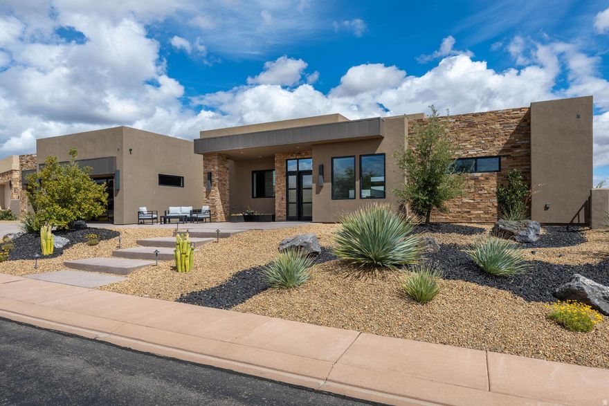 Located behind the gates of The Ledges of St. George, this exceptional new home blends high-end design with comfortable, livable spaces. The open floor plan is bright and inviting, featuring 5 bedrooms (including a custom bunk room), 5 bathrooms, and a dedicated office. The kitchen is thoughtfully designed with Sub-Zero and Wolf appliances, paired with beautiful cabinetry, warm wood flooring, and a cohesive, well-executed interior design throughout. The backyard is a true highlight. A large in- ground pool and hot tub are complemented by multiple fire features integrated into the landscaping, creating a clean, modern outdoor environment. The covered patio with built- in BBQ makes it easy to entertain or unwind year- round. The home is fully automated with Lutron lighting and a Sonos sound system, offering both convenience and a seamless living experience. Set in one of St. George's premier gated communities, with close access to golf, hiking, and endless outdoor recreation.