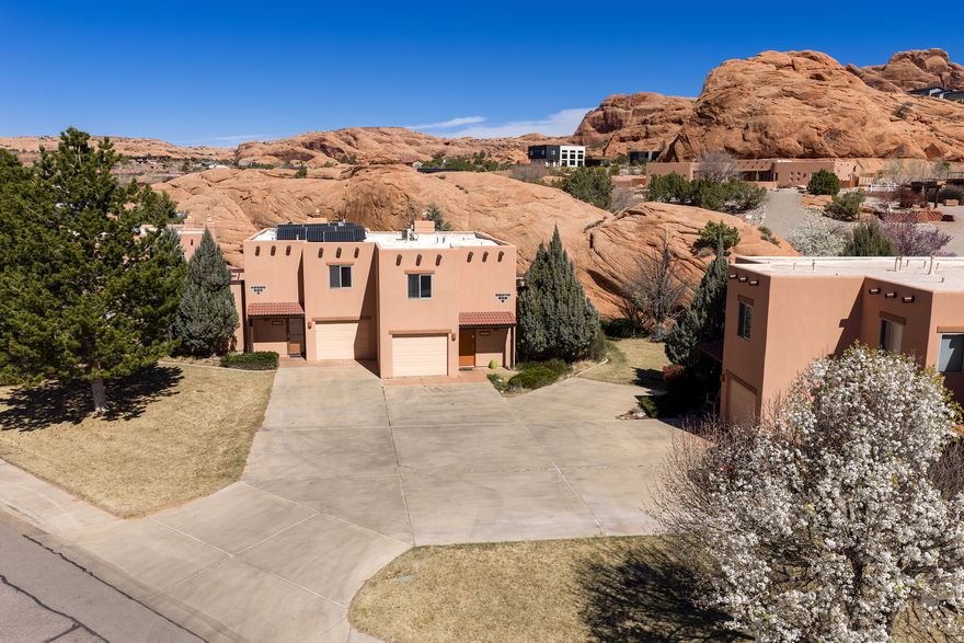 STUNNING LOCATION for this TURNKEY NIGHTLY RENTAL! This spacious Pueblo-style townhome is surrounded by breathtaking red rock formations and features large rooms, an updated kitchen with marble countertops, modern cabinetry, angled bar seating, and stainless steel appliances, plus a cozy gas fireplace to enjoy on cooler nights. Step outside to the expansive stamped and stained concrete patio framed by a massive red rock formation. Enjoy outdoor living with dining area, multiple seating areas, BBQ grill, and a 6-person hot tub to soak away the soreness after your adventures in the amazing Moab desert country. The large primary suite includes a king sleigh bed, futon, and en-suite bath with tile tub/shower and marble countertop. Upstairs offers two additional oversized bedrooms and access to the rooftop patio with incredible panoramic red rock views. One bedroom also features a pool table, arcade game, and basketball shoot game, creating the perfect hangout space. Fully furnished and turnkey- an incredible nightly rental opportunity in a truly unique Moab setting. All information deemed reliable but not guaranteed. Buyer to verify.