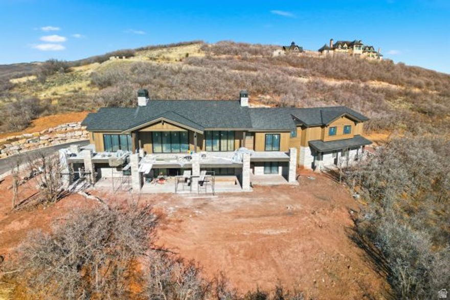 Welcome to your dream home in a private, gated community where modern luxury meets breathtaking natural beauty. This exquisite transitional modern residence offers 6,522 square feet of thoughtfully designed living space on a sprawling 10.7-acre lot, with 210-degree sweeping views of Deer Valley, Park City Mountain, and the Uinta Range. The striking limestone exterior, paired with sleek metal accents and a durable asphalt shingle roof, highlights the refined craftsmanship and timeless design. Inside, the open-concept layout features a gourmet kitchen with a large island, flowing into a spacious living area centered around a limestone fireplace. Step out to the expansive deck and covered patio - perfect for entertaining, relaxing, and enjoying serene sunsets and abundant wildlife. An inground spa just off the back patio adds the ultimate touch of relaxation. With 5 bedrooms and 6.5 bathrooms, this home easily accommodates family and guests. A second-level game room with bar, cozy bunk room, exercise space, and 3-bay garage with heated driveway round out the impressive amenities. Ranches at the Preserve offers not only unmatched views and privacy but also the rare opportunity to add a guest house, barn, and caretaker's cottage - making full use of the 10+ acres. Horses are allowed on the property, providing a true ranch lifestyle for equestrian enthusiasts. Ideally located: 25 minutes from downtown Salt Lake City, 30 minutes from SLC International Airport, 10 minutes to Kimball Junction shopping and dining, and 15 minutes to world-class skiing and historic Old Town Park City. Access is easy via I-80 through Jeremy Ranch or Kimball Junction. Come experience the perfect blend of elegance, space, and convenience for $7.5M. Schedule your private showing today and immerse yourself in the unmatched beauty of Red Hawk living.
