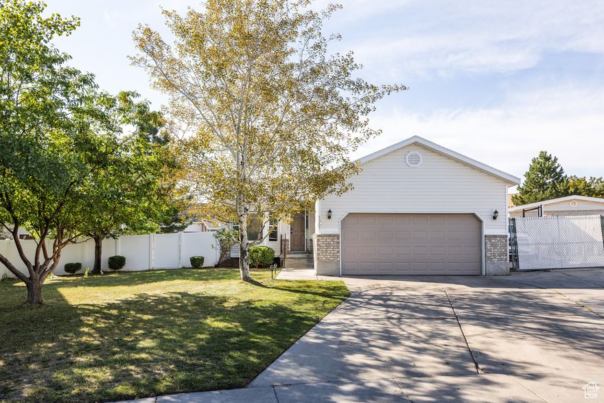 This lovely Kearns home-perched in a cul-de-sac that lends a bit of privacy in an established and tree-lined neighborhood-is bringing a good deal of charm and plenty of desirable features to the table. A somewhat traditional layout is complemented by high ceilings and an abundance of natural light throughout, making it feel even more spacious than its 2100 square feet. The kitchen is spacious and well laid-out-connected seamlessly to the back yard via a set of sliding glass doors, a small deck provides the setting for BBQs or dinners al fresco. With 5 bedrooms and 3 bathrooms, this is a home with room for everyone, and the lower level feels open and bright, thanks in part to large window wells-down here, you'll find a large living area, two of the aforementioned bedrooms, and a dedicated laundry room. The back yard is brimming with potential: plenty of lawn space and a pair of garden boxes lend themselves to fresh veggies and easy gatherings. A gated pad just next to the garage also means you've got room for your RV or boat. The best part? This area offers plenty of parks nearby, and the home is within walking distance of both the Kearns Olympic Oval and the Kearns Oquirrh Park Fitness Center. Translation: the good life is waiting for you on Alpine Flower Circle.