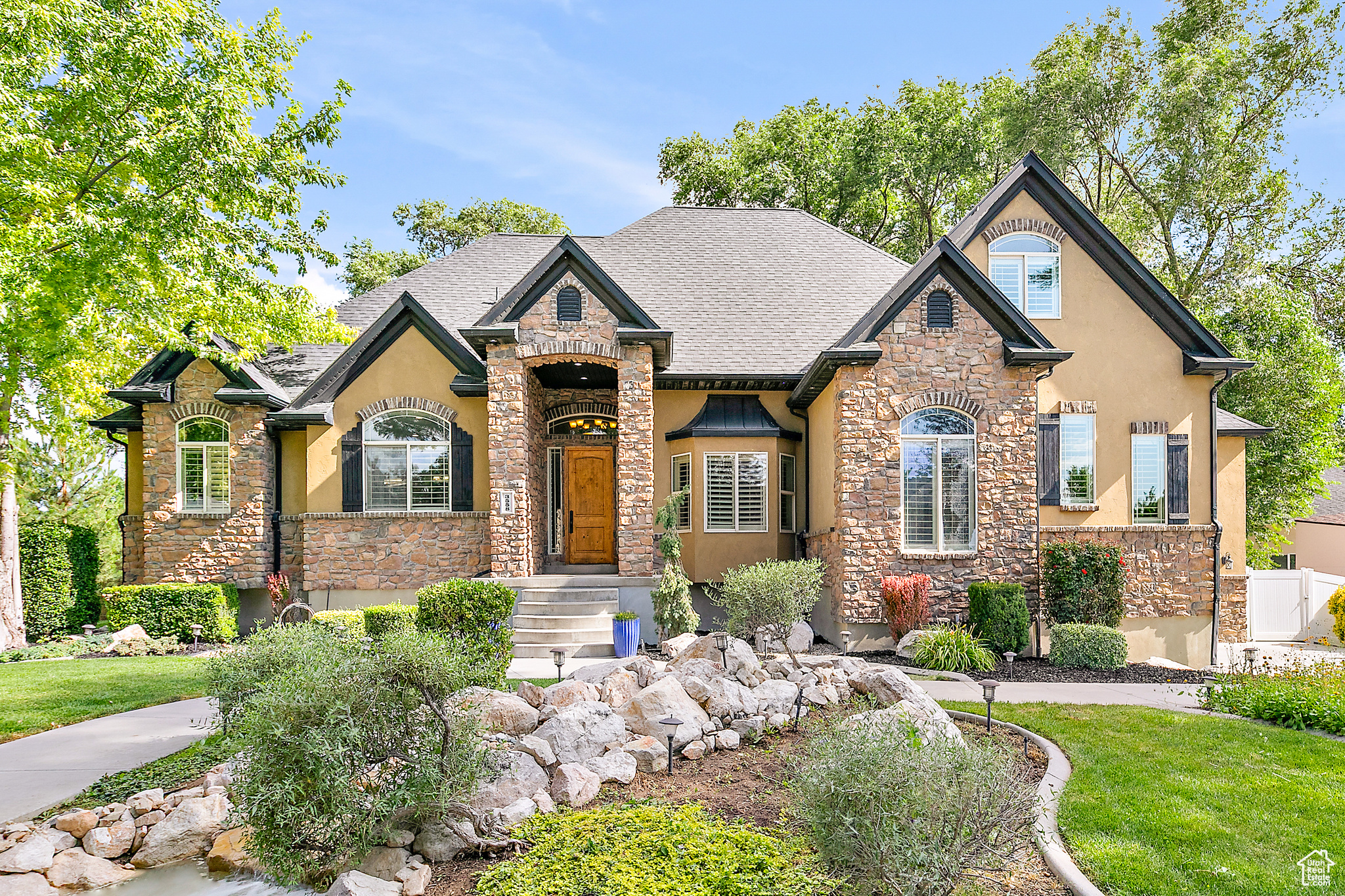 This amazing home gets responses from visitors like, 'I feel like I'm in a secluded retreat' and 'do you feel like you're always on vacation living here?' lol. No doubt its location on 'New Private Drive' starts things off in that direction. Walk through the home to the elevated rear deck and take in the 0.46 acres of green space, featuring a mature tree canopy that provides shade and privacy, with no back neighbors. And guess what? You're just getting started! This six-bedroom home boasts more features than can be listed here, but we'll highlight a few key ones. Up on the second floor, you have two bedrooms, a shared full bath, a large game room/theatre room and its own HVAC (new). At ground level, let's mention the main laundry, an updated designer kitchen, which is perfect for entertaining; several people can cook and visit while preparing and serving the crowd. It was designed to accommodate a smooth flow of people coming through to dish up food, which they could then sit in the spacious seating area and enjoy. The venue has accommodated many parties, serving 25-55 people. The primary suite is a true retreat with a steam shower, soaking tub, and two walk-in closets. Then we get to the basement with a fully finished three-bedroom, mother-in-law suite (ADU) with a separate entrance, its own W&D, high ceilings, plantation shutters, and a large, mostly shaded patio. The ADU has been rented for the 10 years the sellers have lived here for $2,200 monthly; they could have raised the rent, but preferred longer-term tenants. New Private Dr is only four blocks from The District shopping center in South Jordan and 5 minutes to both Bangerter Hwy and Mountain View shopping center for easy access to all you need.